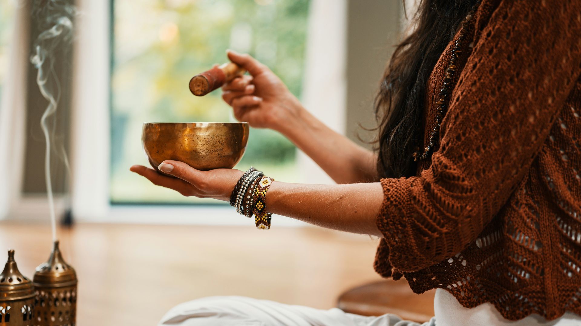 woman in brown knit sweater holding brown ceramic cup