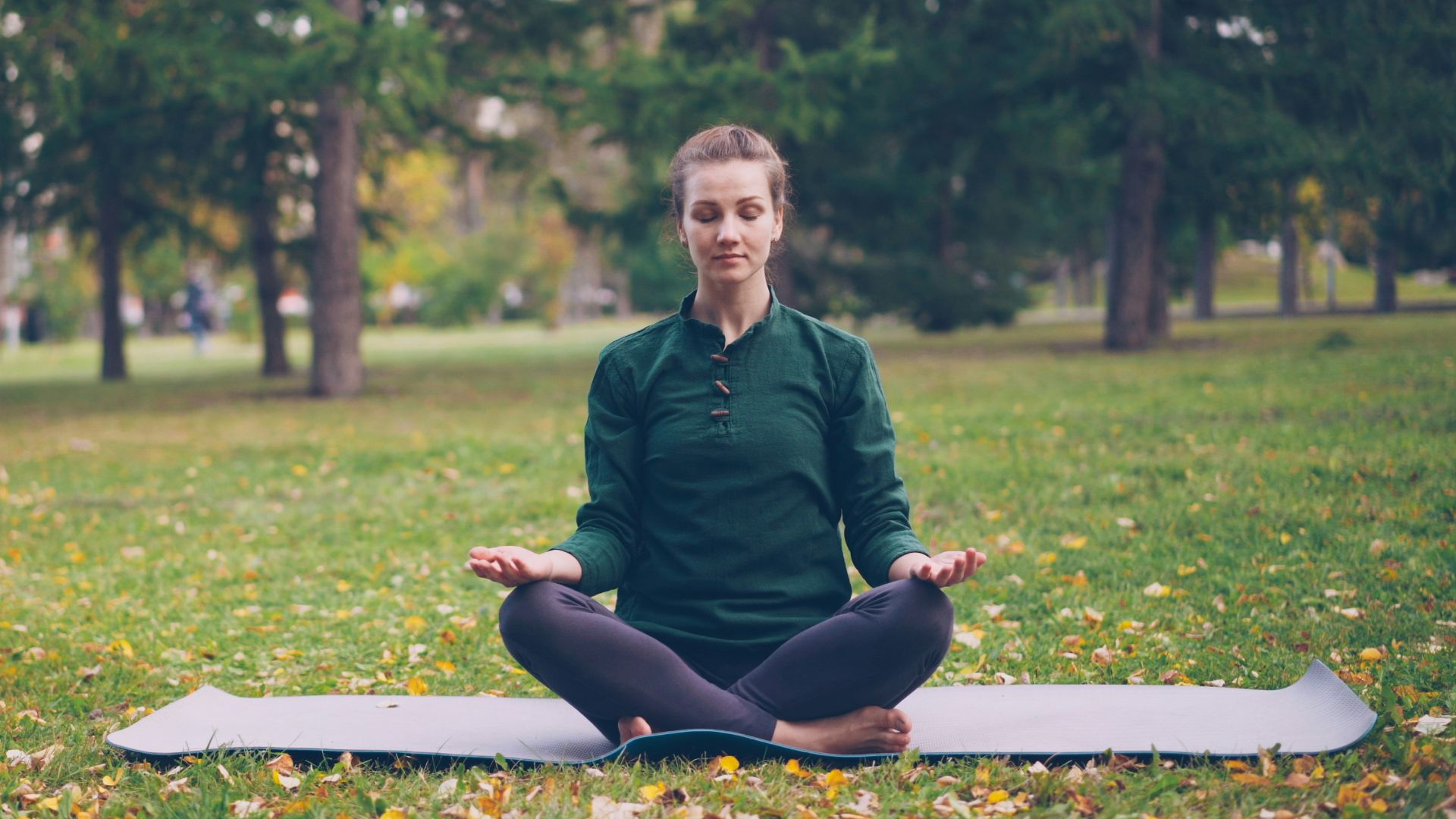 Woman meditating in a peaceful park setting