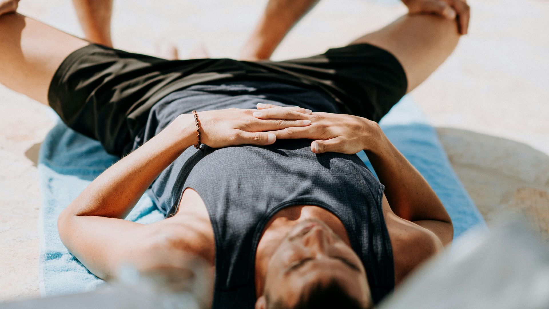 man pressing man's legs during daytime
