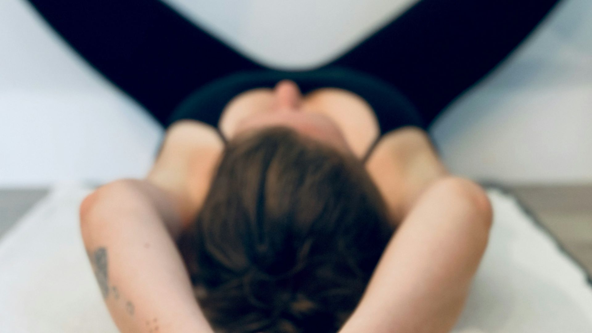 woman in black tank top lying on bed
