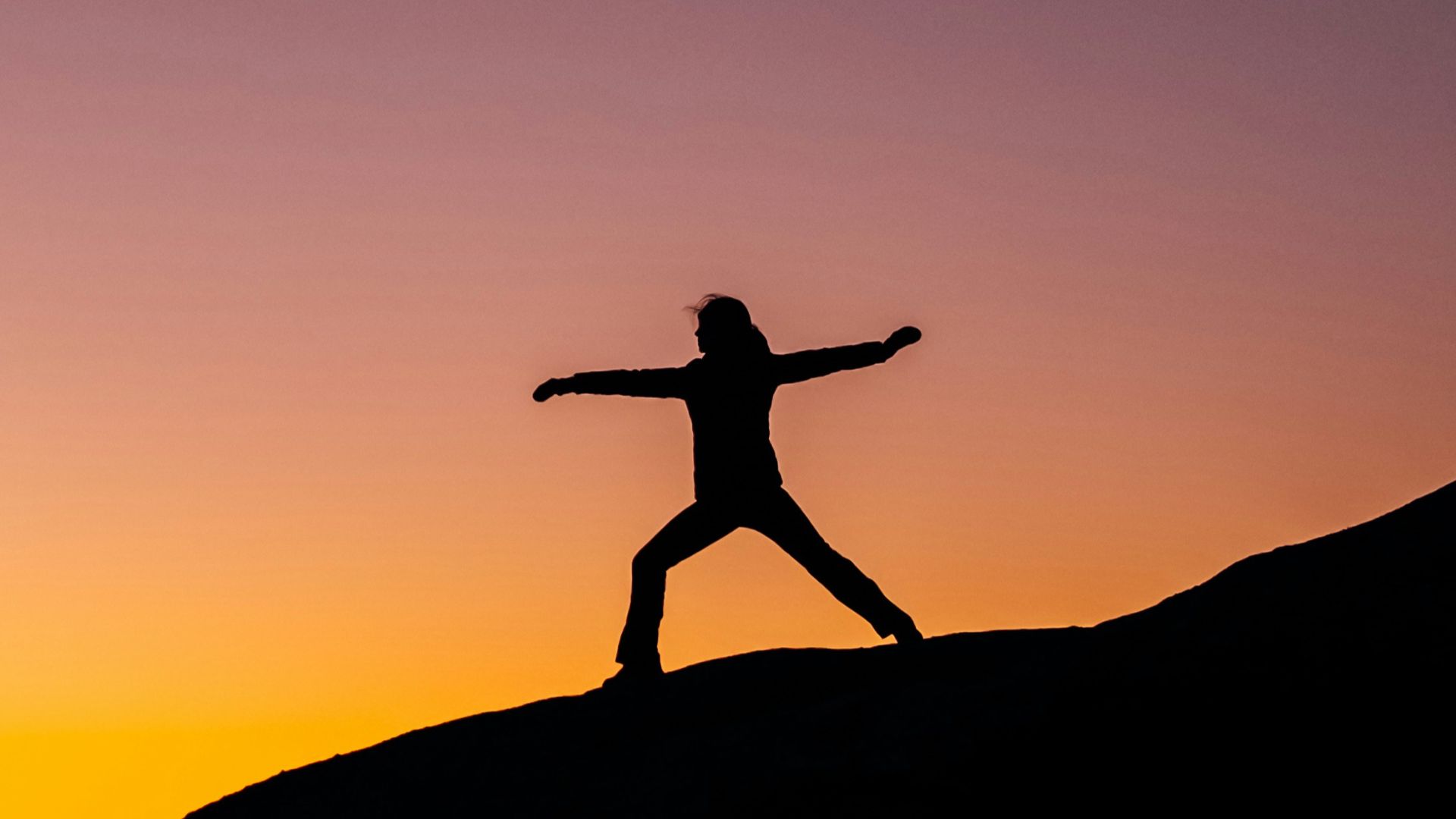 shillouette photo of person standing at the peak