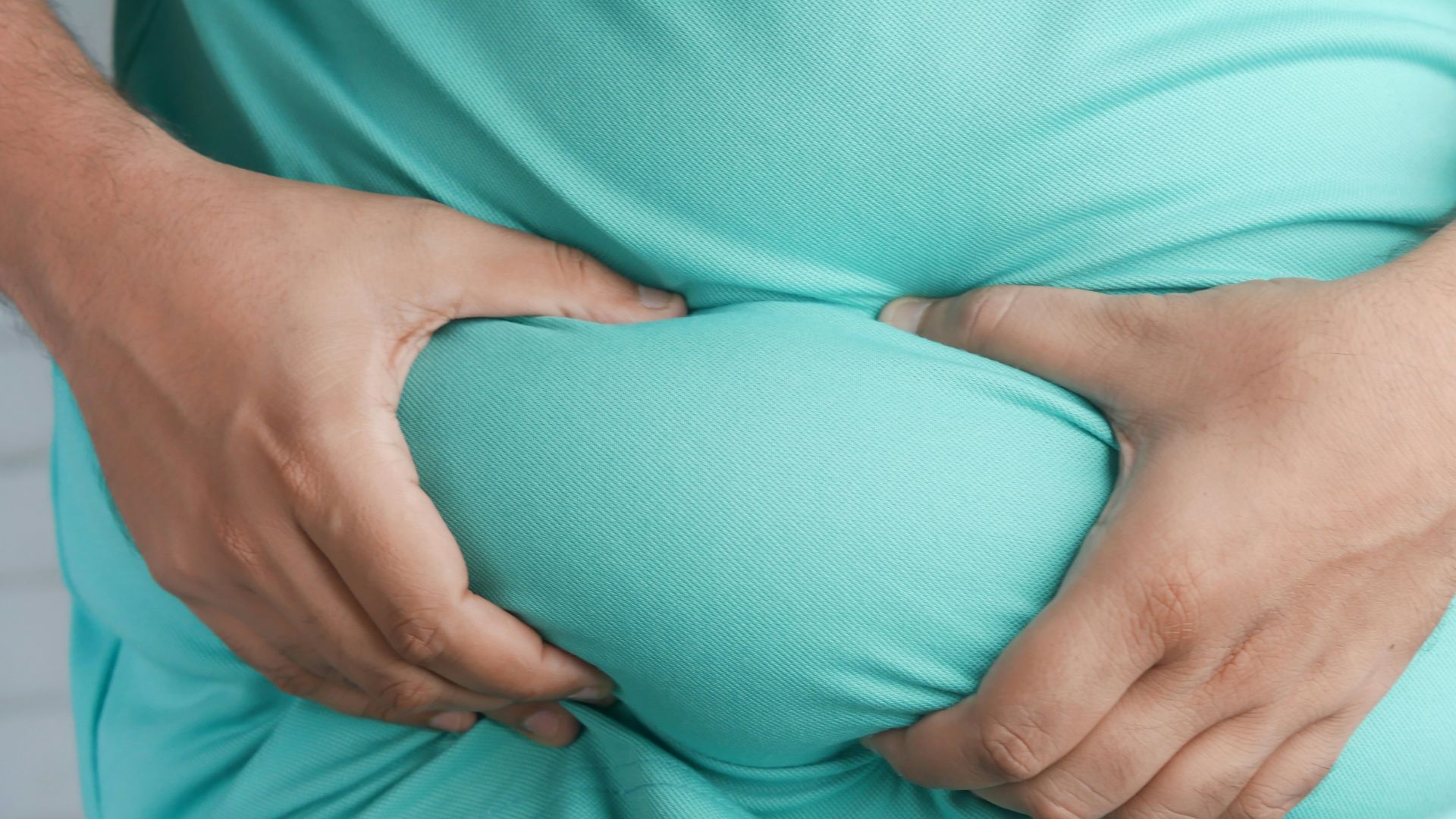 a man holding his stomach with his hands