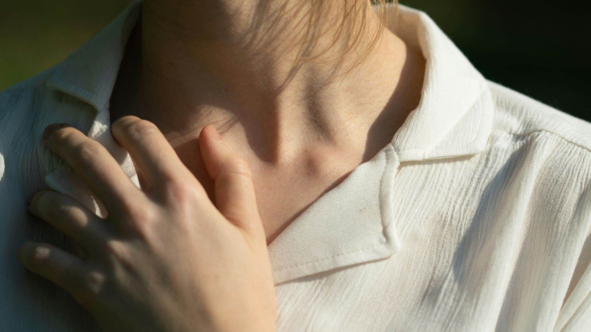 a woman wearing a white shirt and a black watch