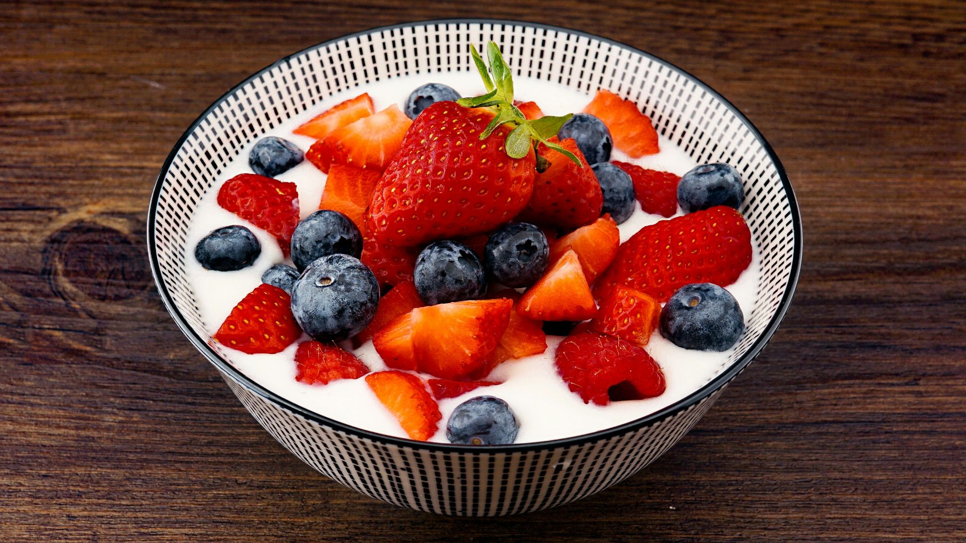 strawberry and blackberries on top of brown table