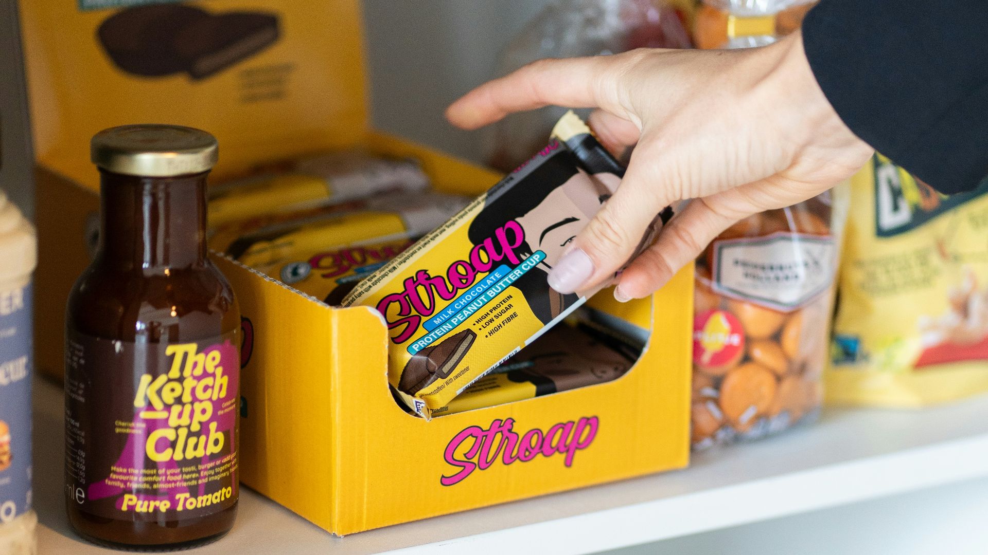 a person reaching for a bag of food on a shelf
