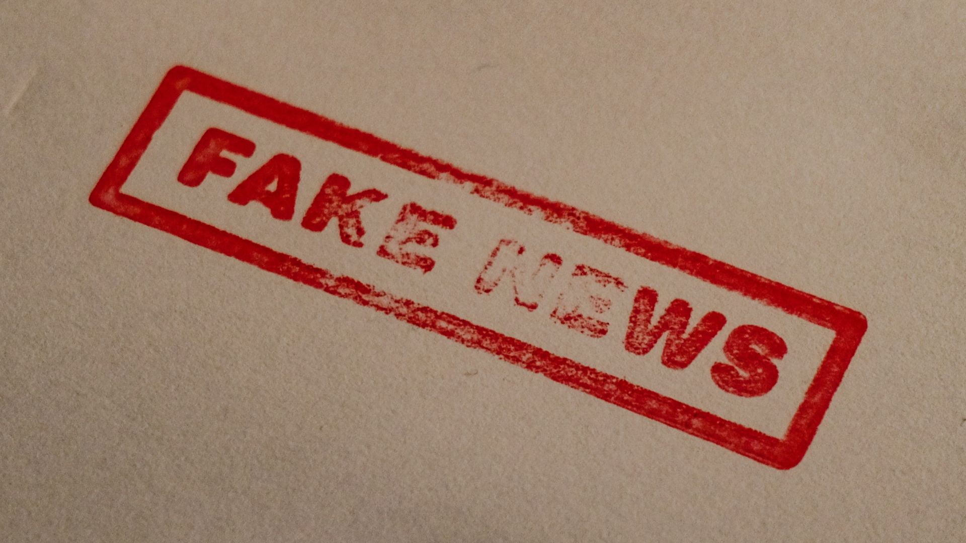 a stamp that reads fake news on a piece of paper