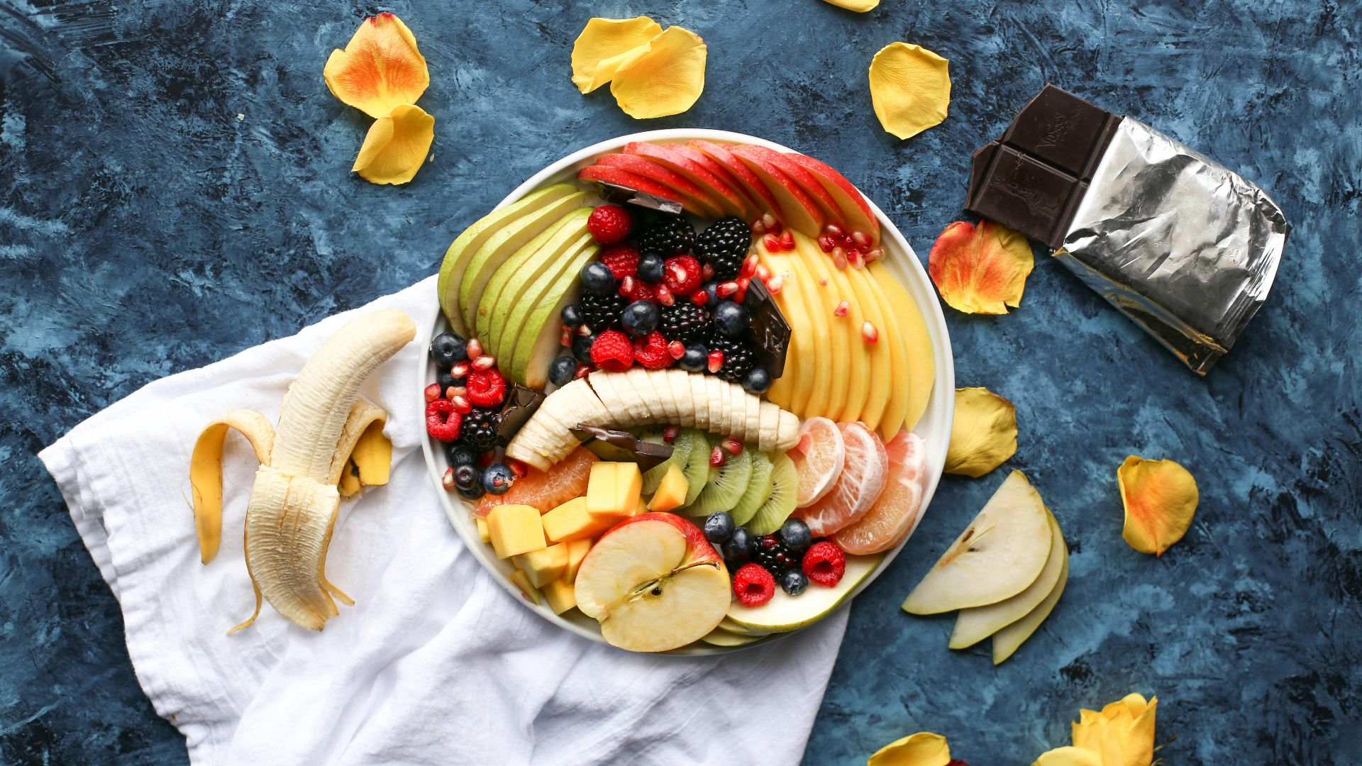bowl of sliced fruits on white textile