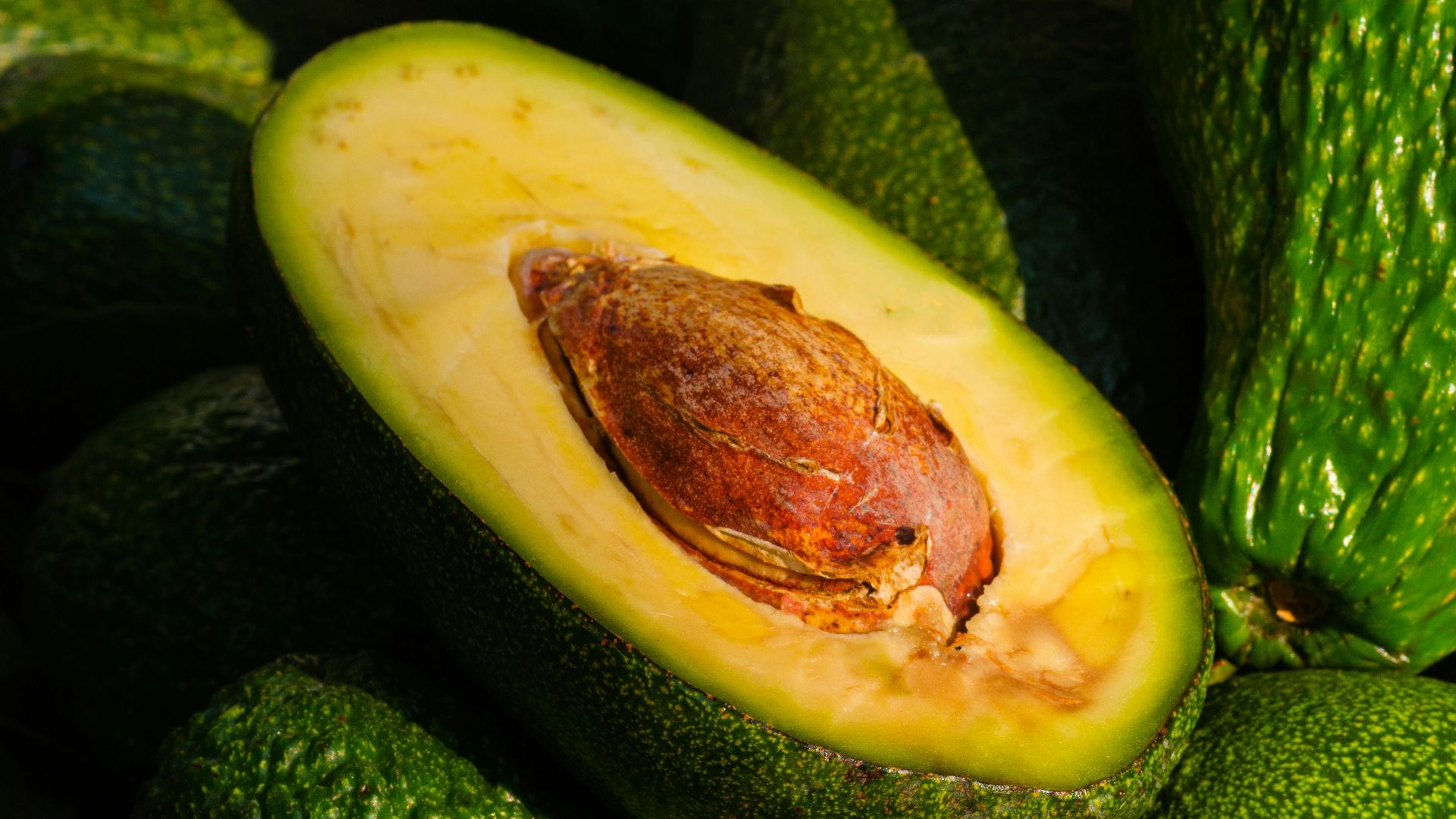 a pile of green avocados sitting on top of each other