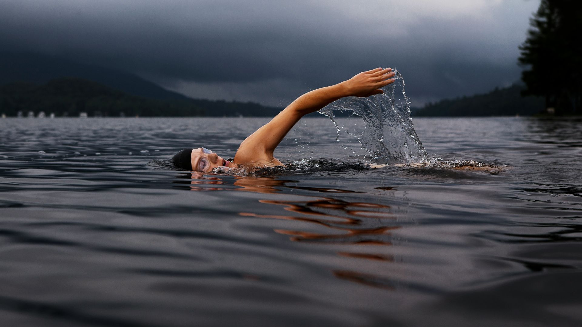 man swimming on body of water