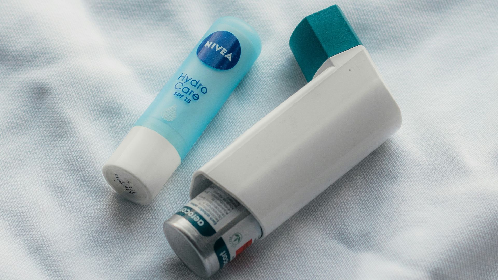 two toothbrushes sitting on top of a white sheet