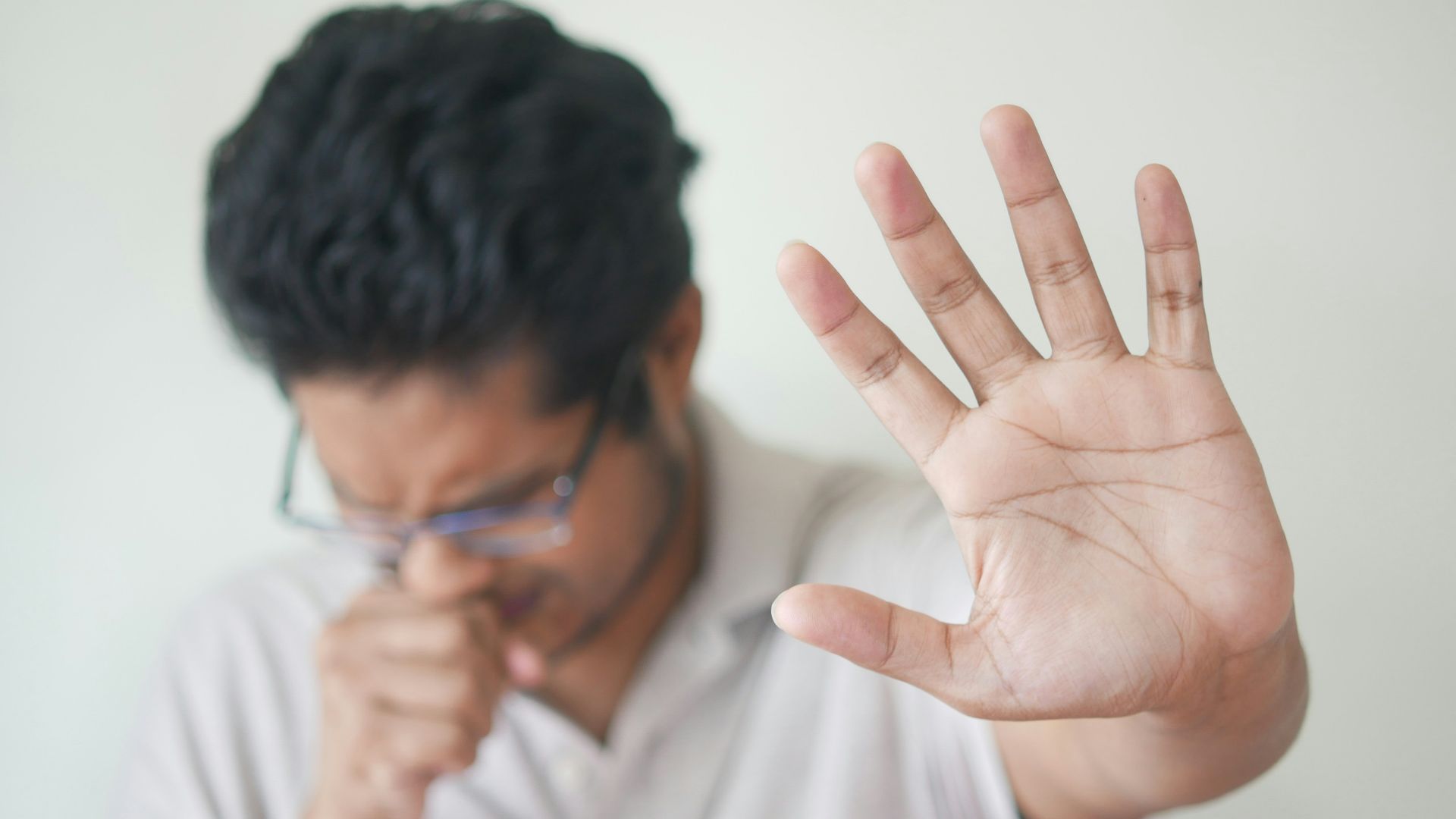 a man holding his hand up in front of his face