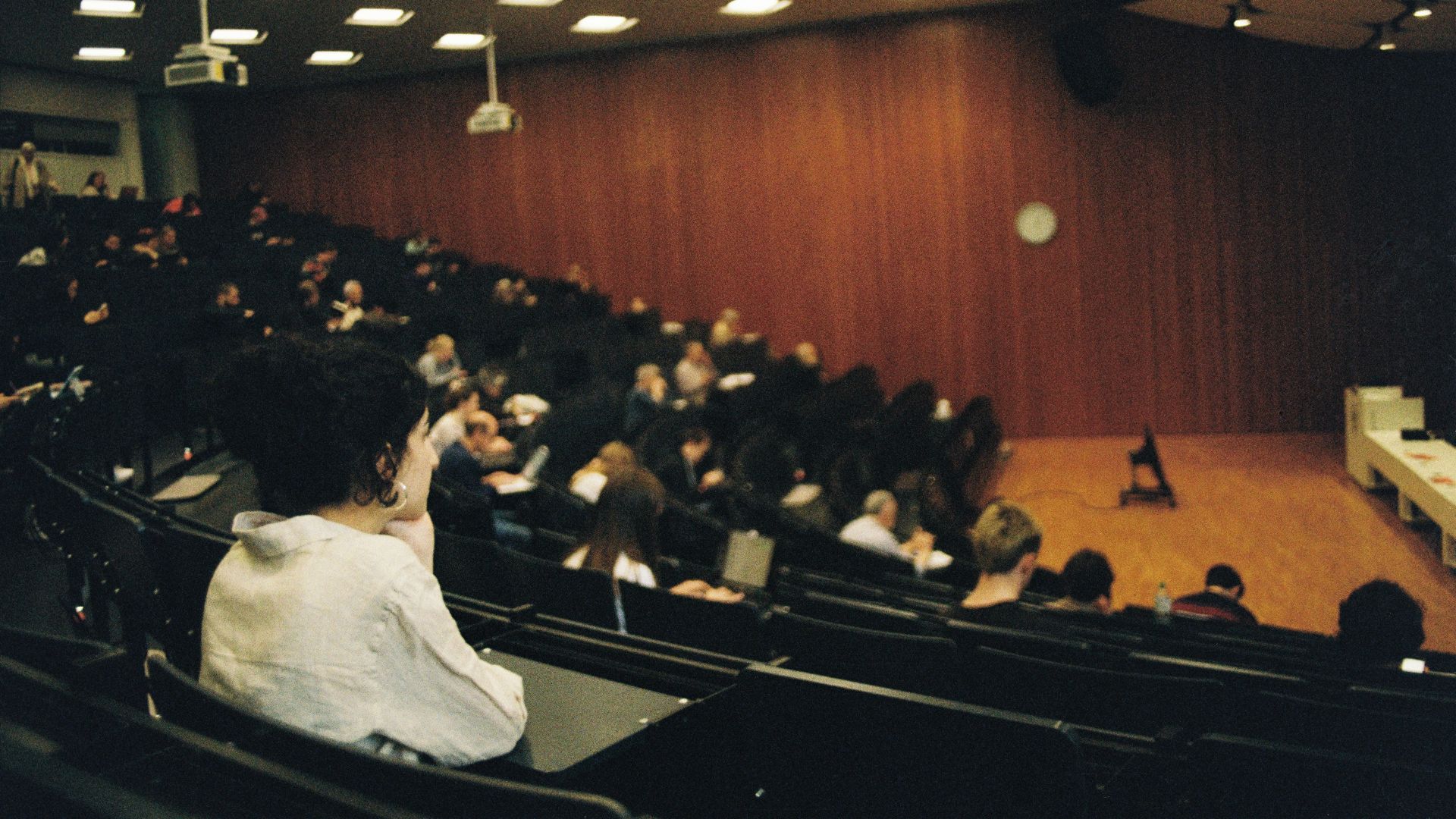 People attend a lecture in a large auditorium.