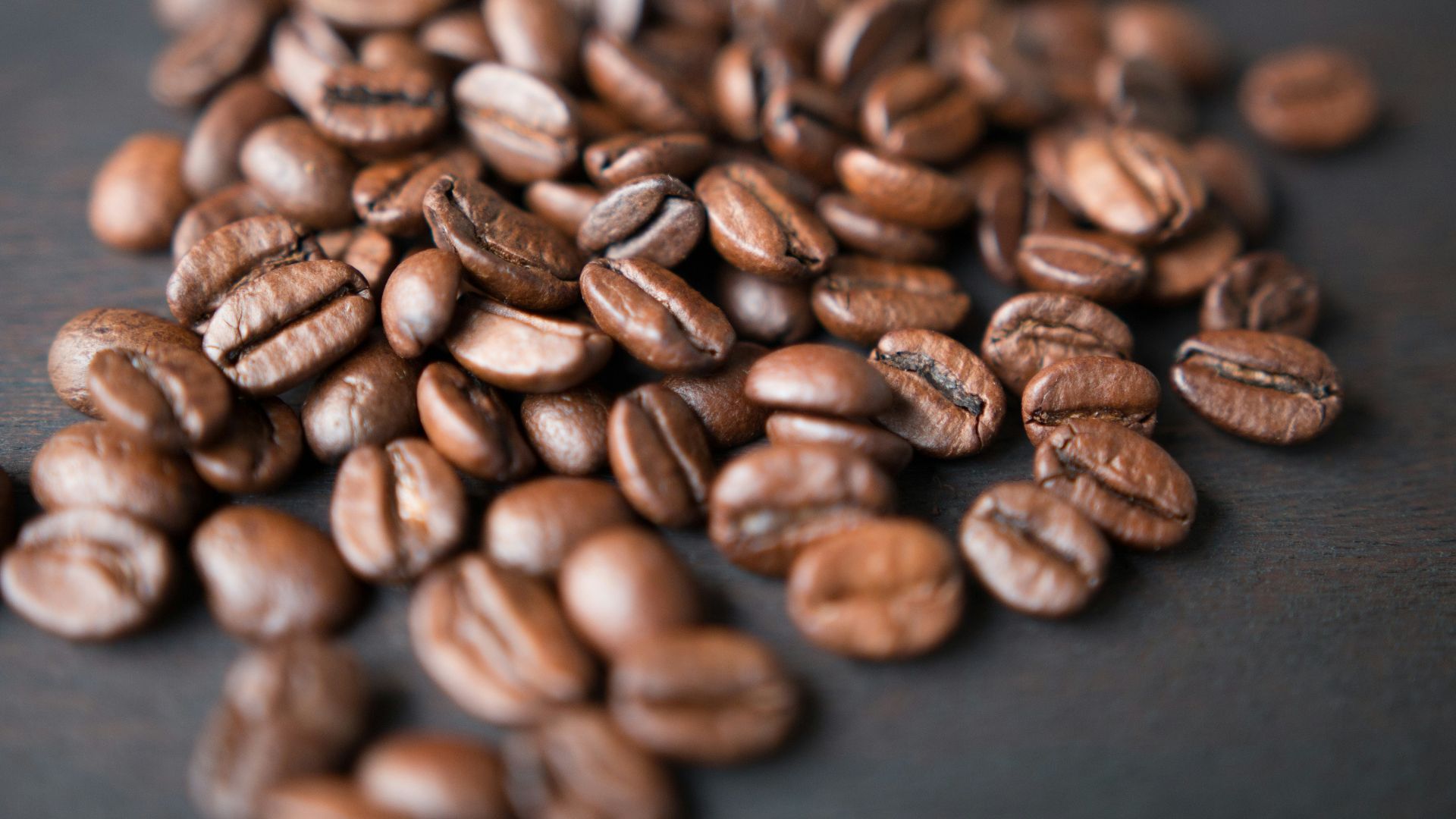 brown coffee beans on gray surface