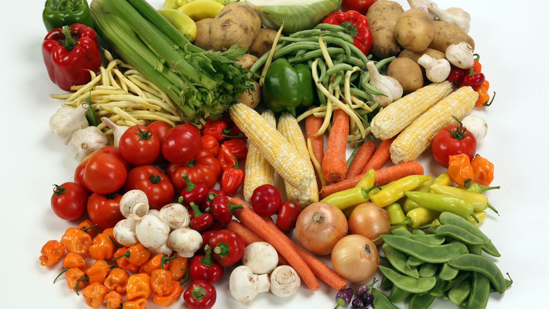 a pile of different types of vegetables on a white surface