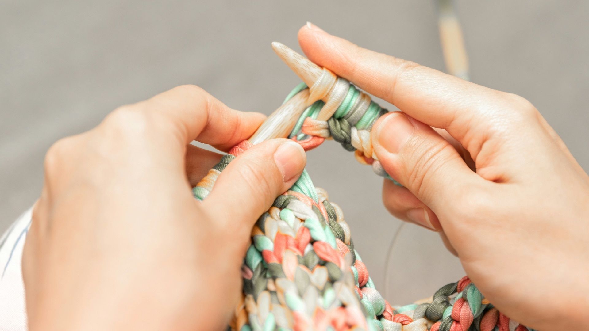 a woman is knitting a piece of fabric
