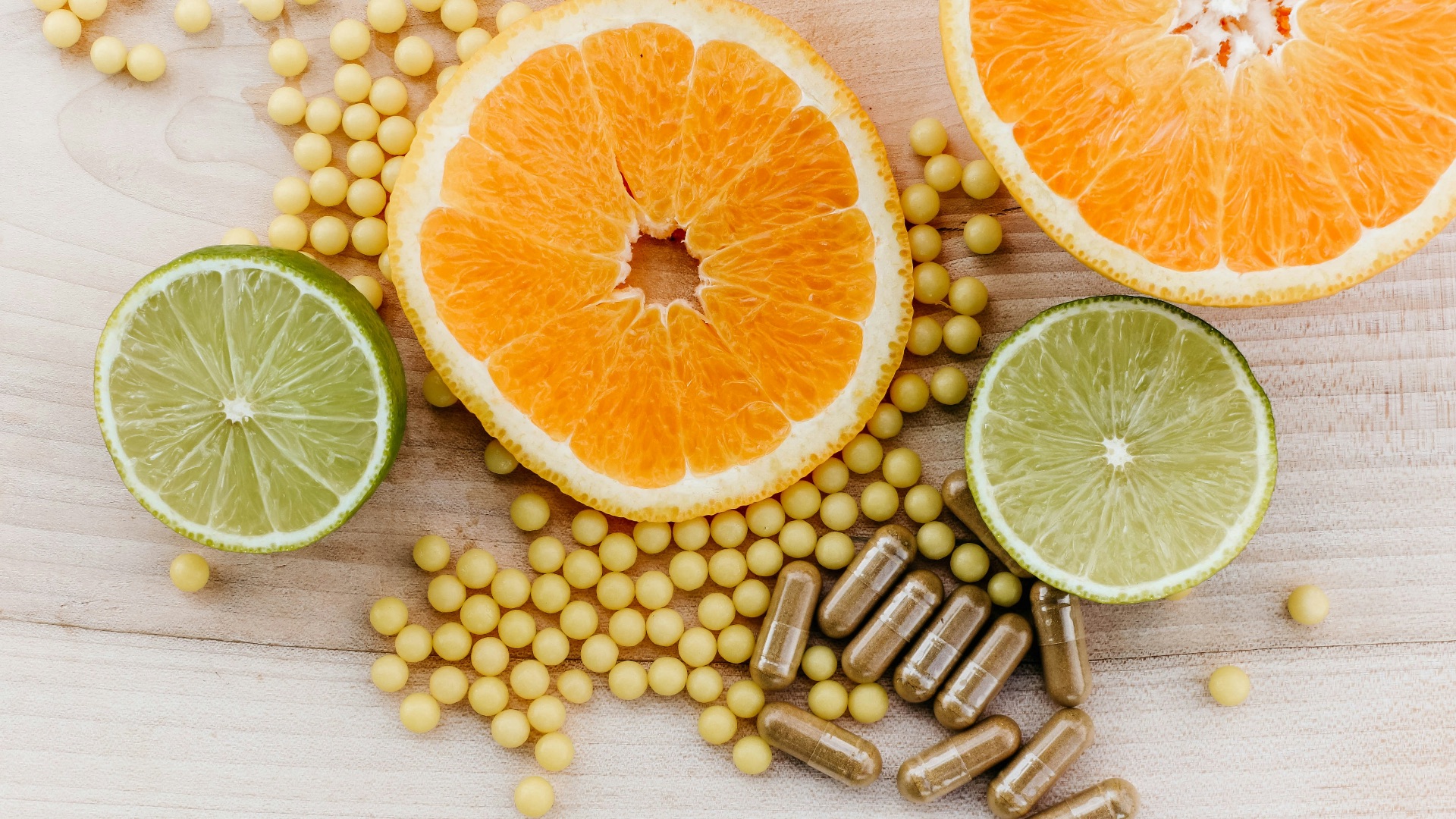 oranges, peas, and limes on a wooden table
