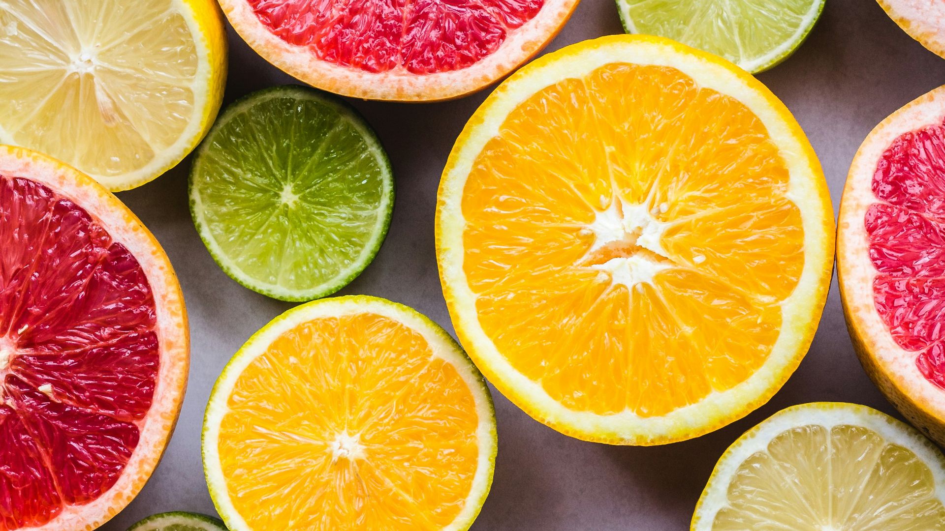 flat lay photography of sliced pomegranate, lime, and lemon