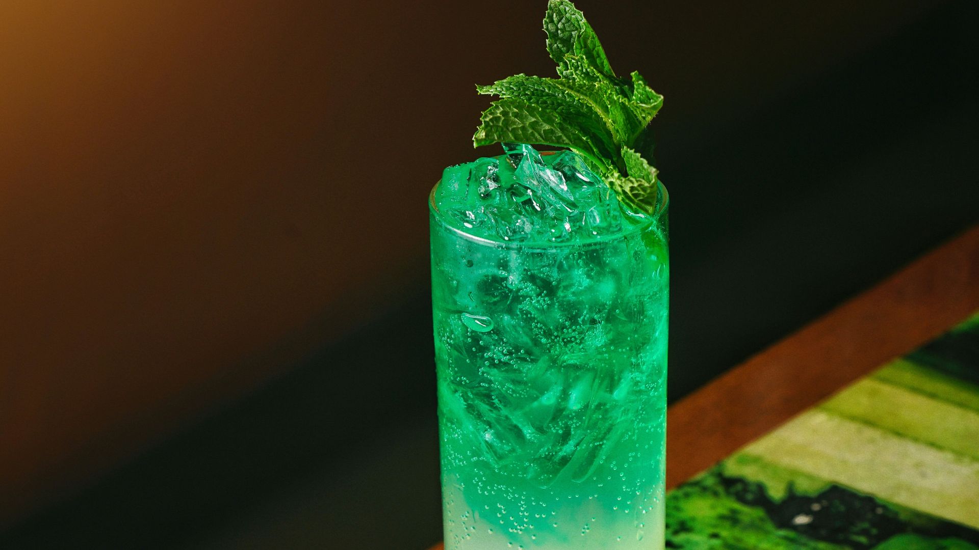 a green and yellow drink sitting on top of a wooden table