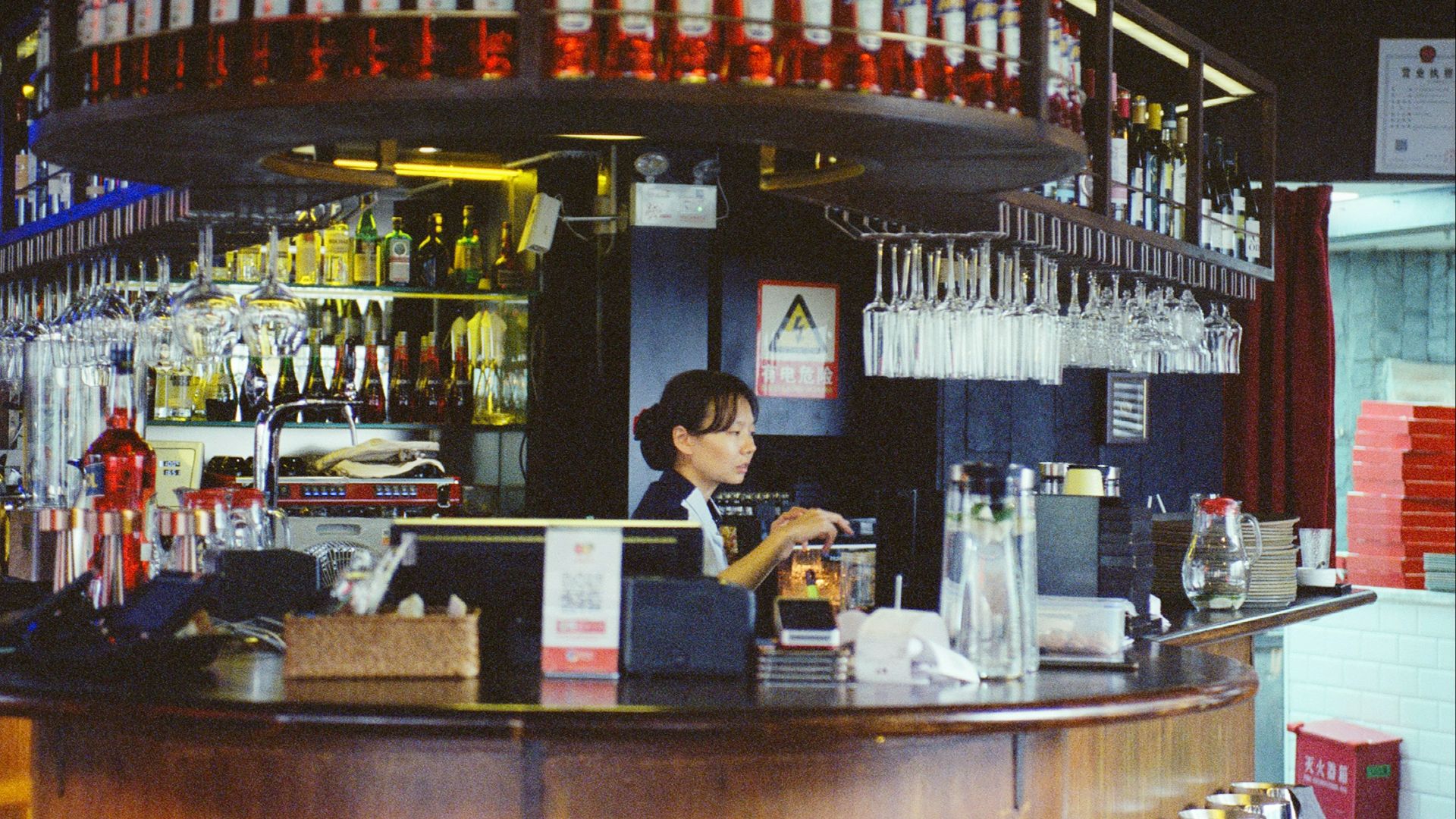 Bartender working behind a bar with bottles