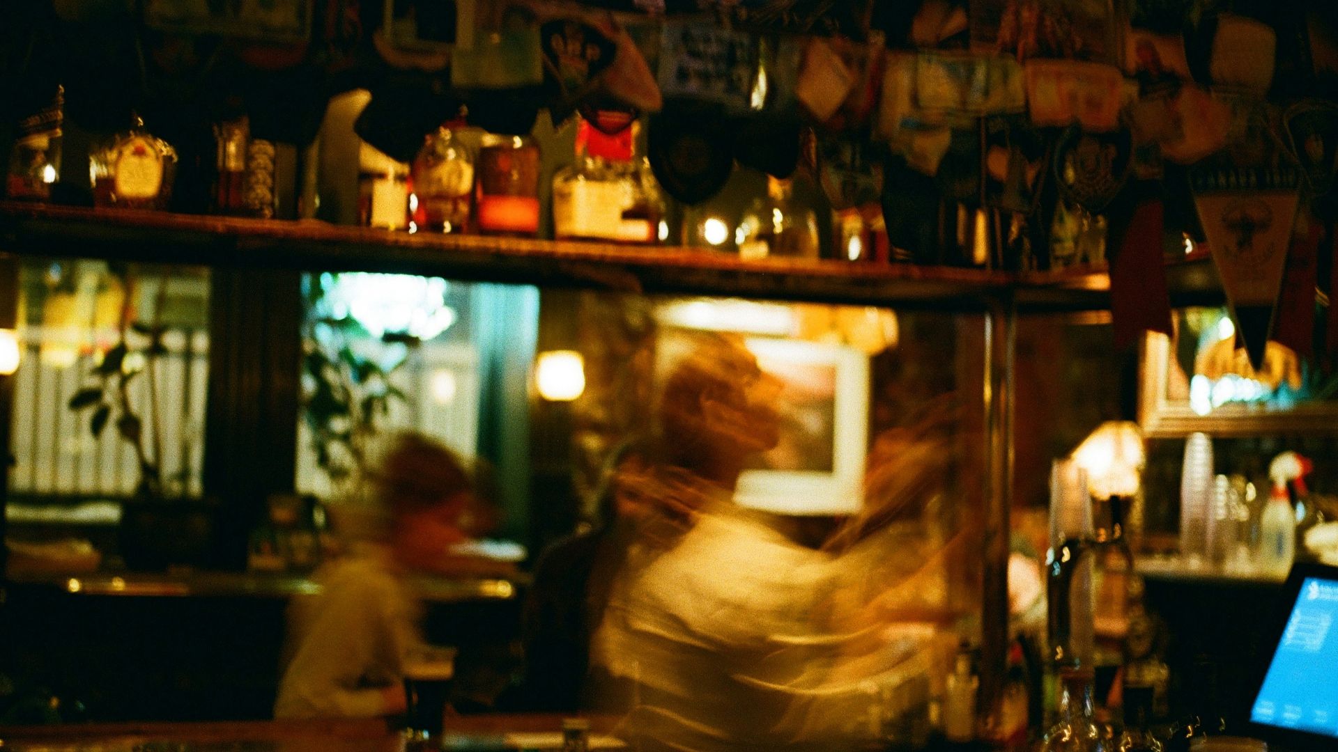 A blurry photo of a bar with a laptop on the counter