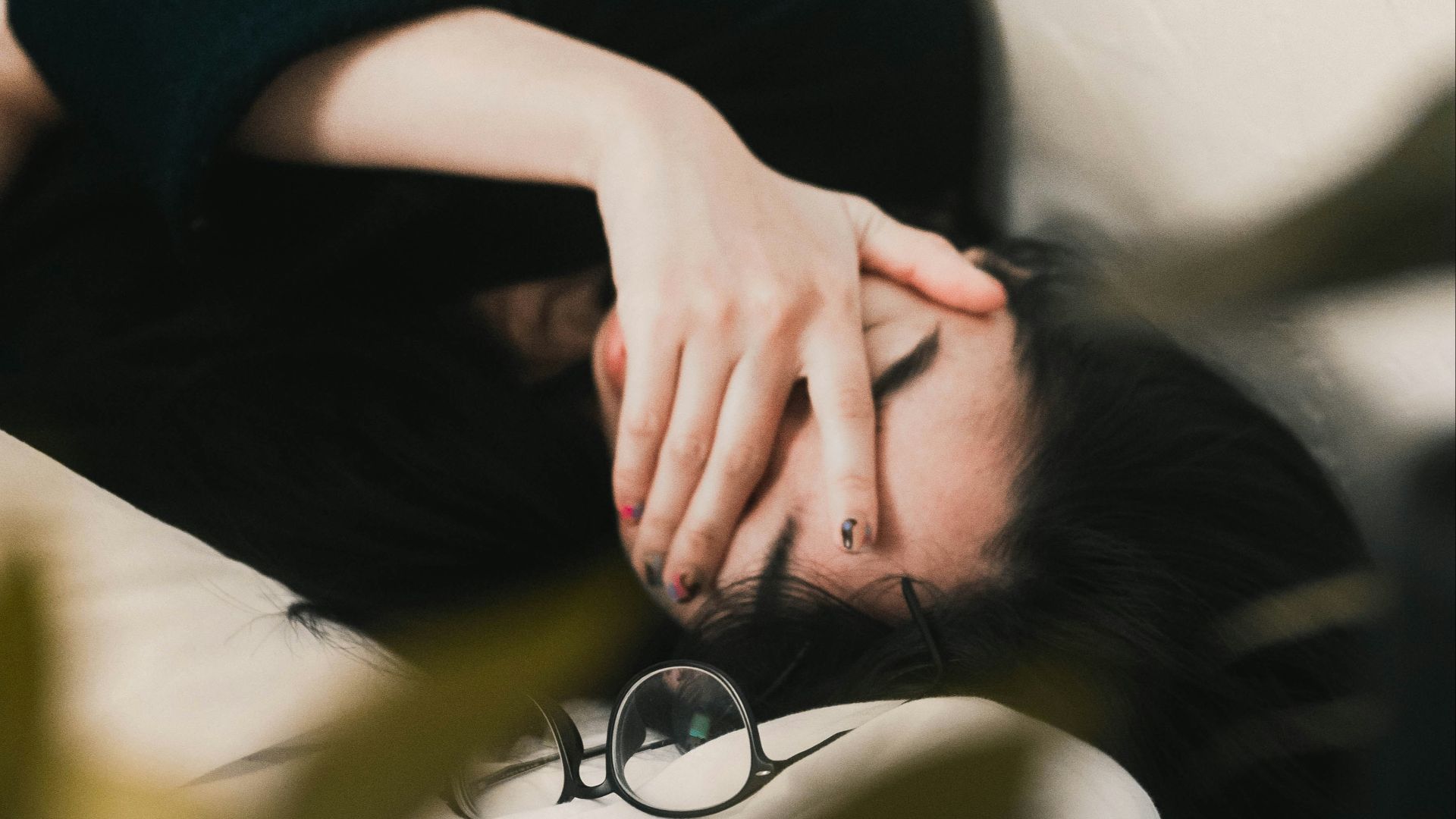 woman in black long sleeve shirt covering her face
