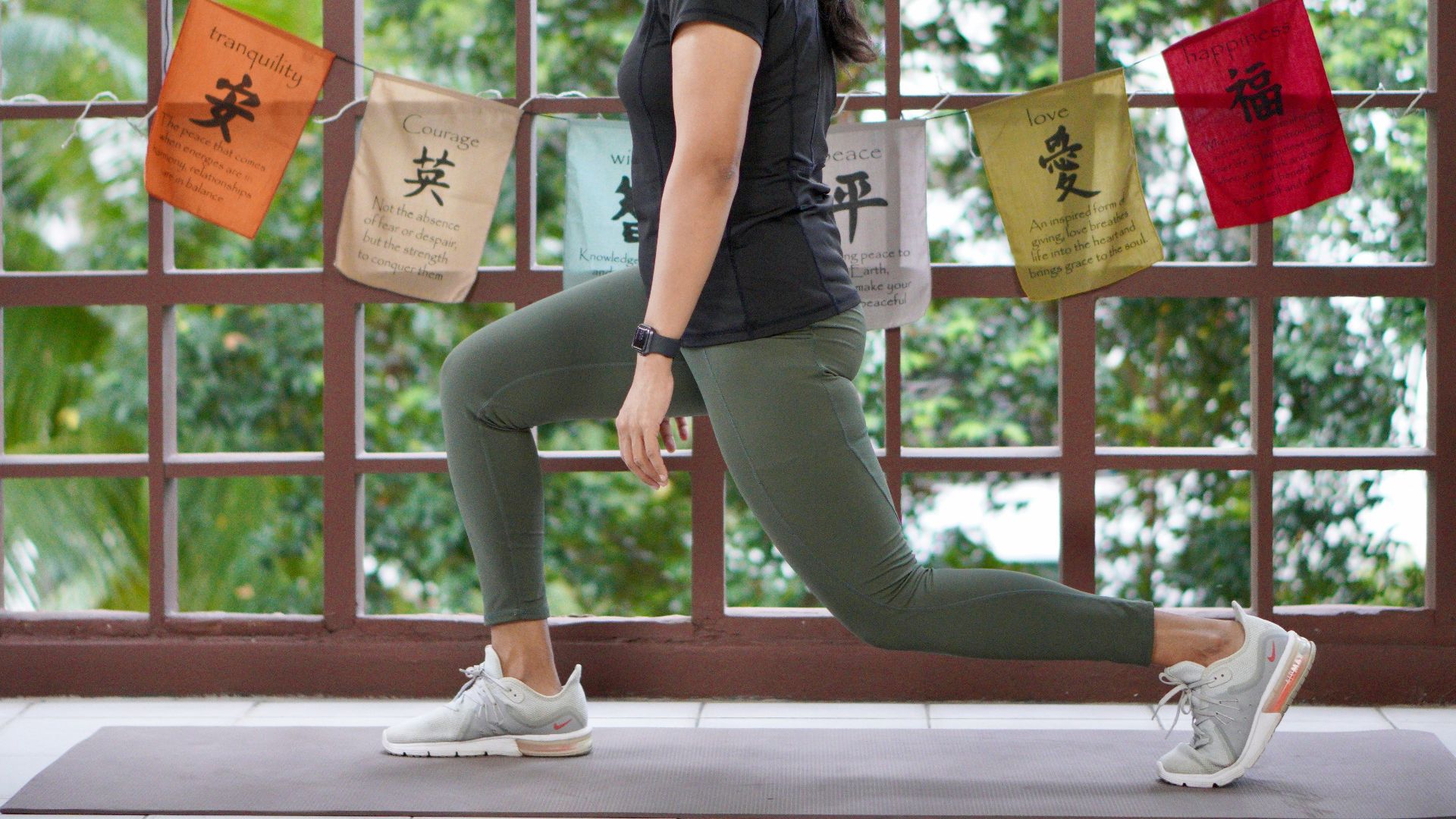 a woman in a black shirt is doing yoga