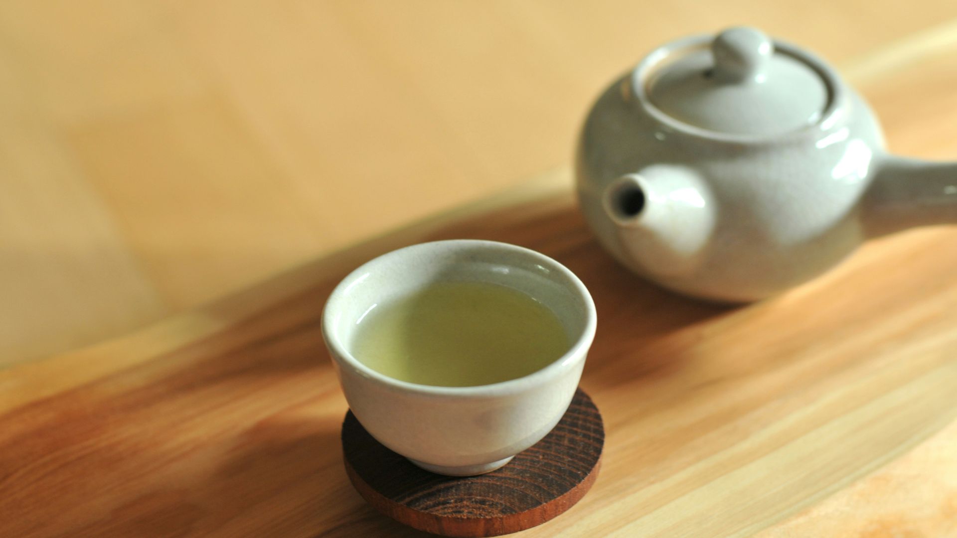 white ceramic teacup on brown wooden table