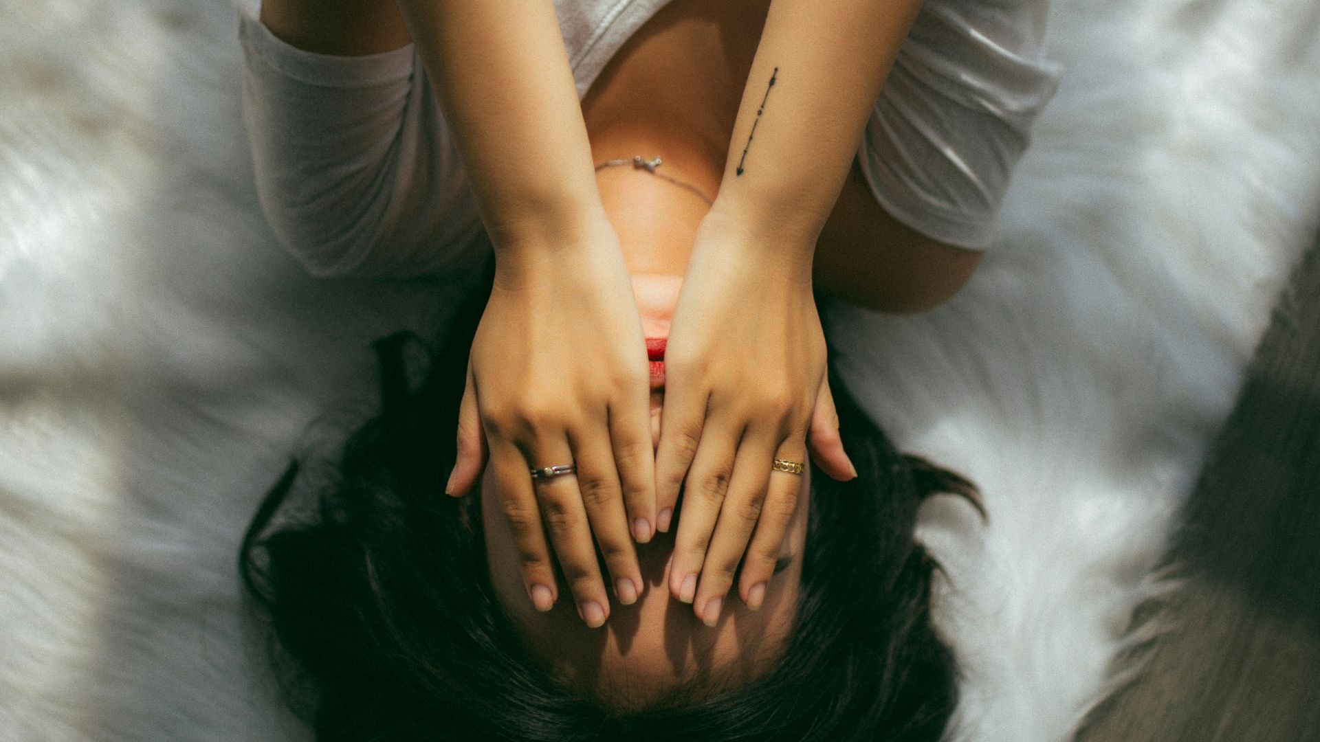 a woman holds her hands over her face