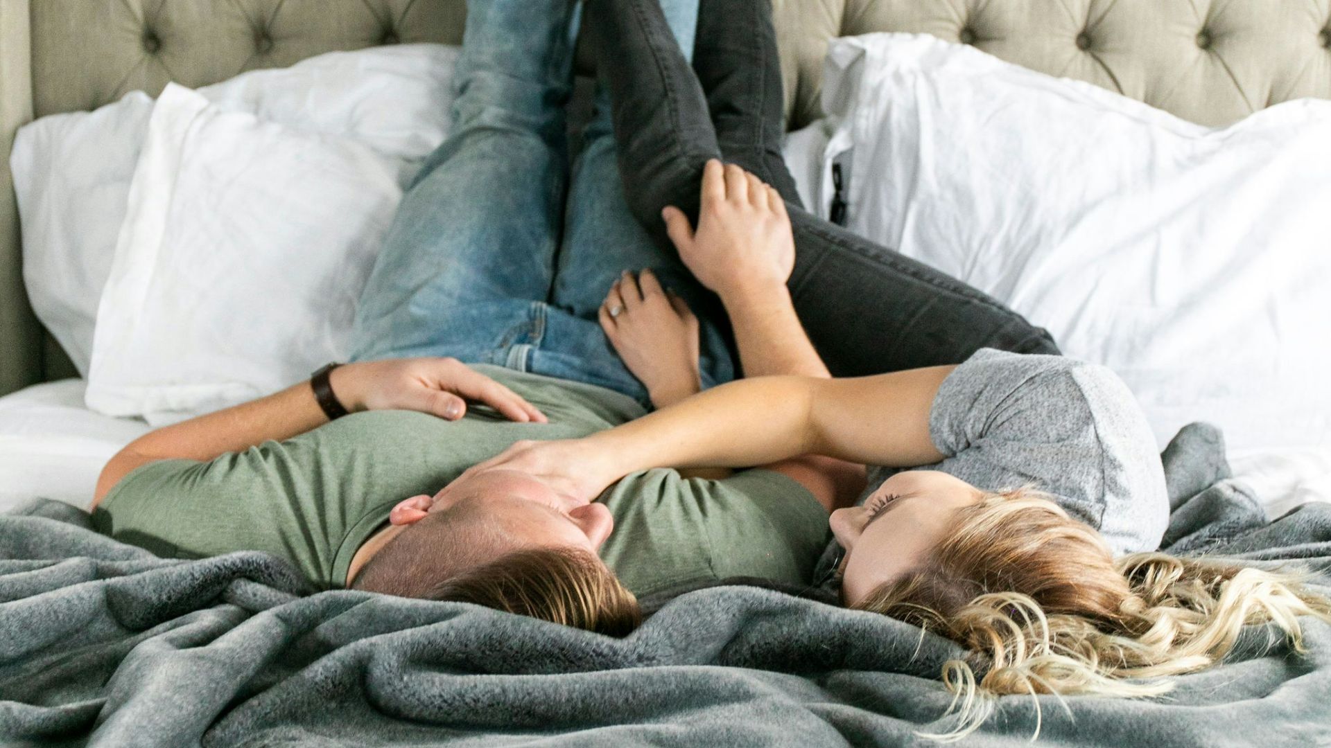 woman in blue denim jeans lying on bed