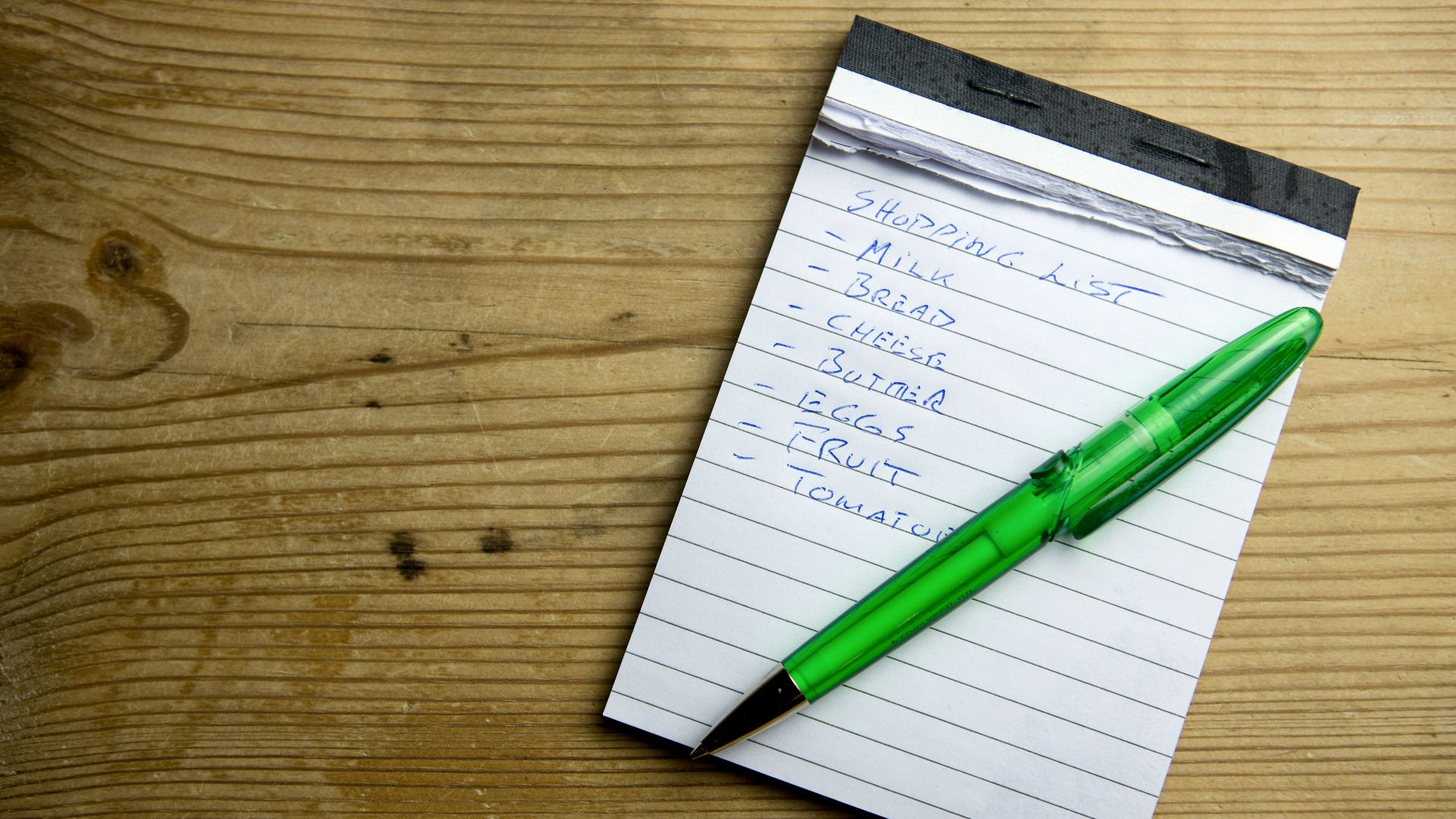 a notepad with a green pen sitting on top of it