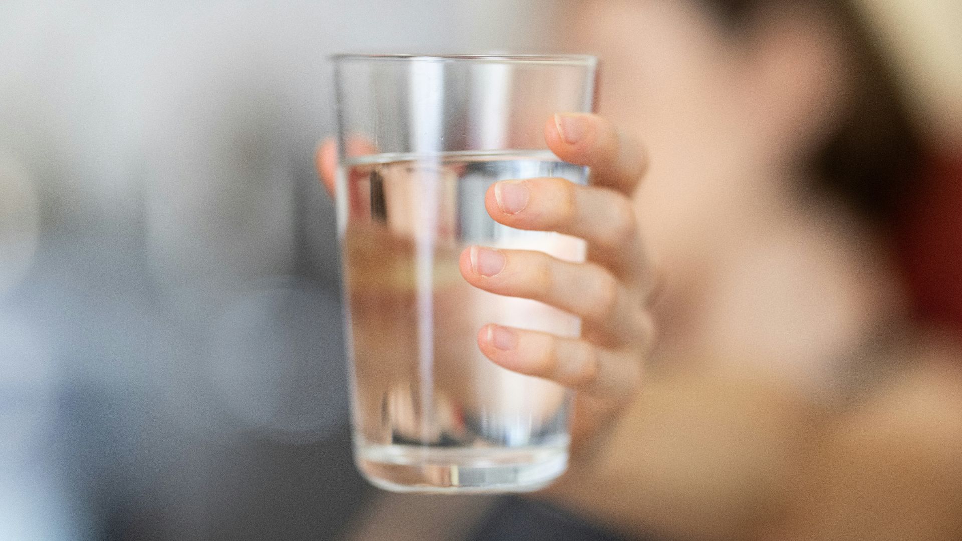 person holding clear drinking glass