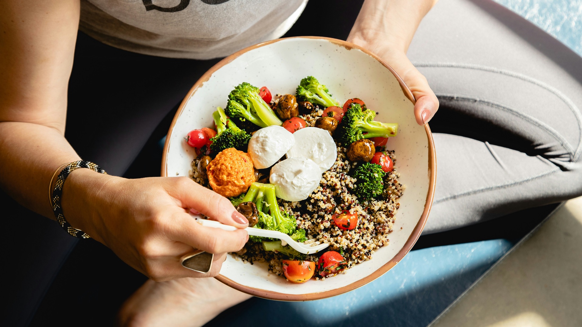 a woman is holding a bowl of food