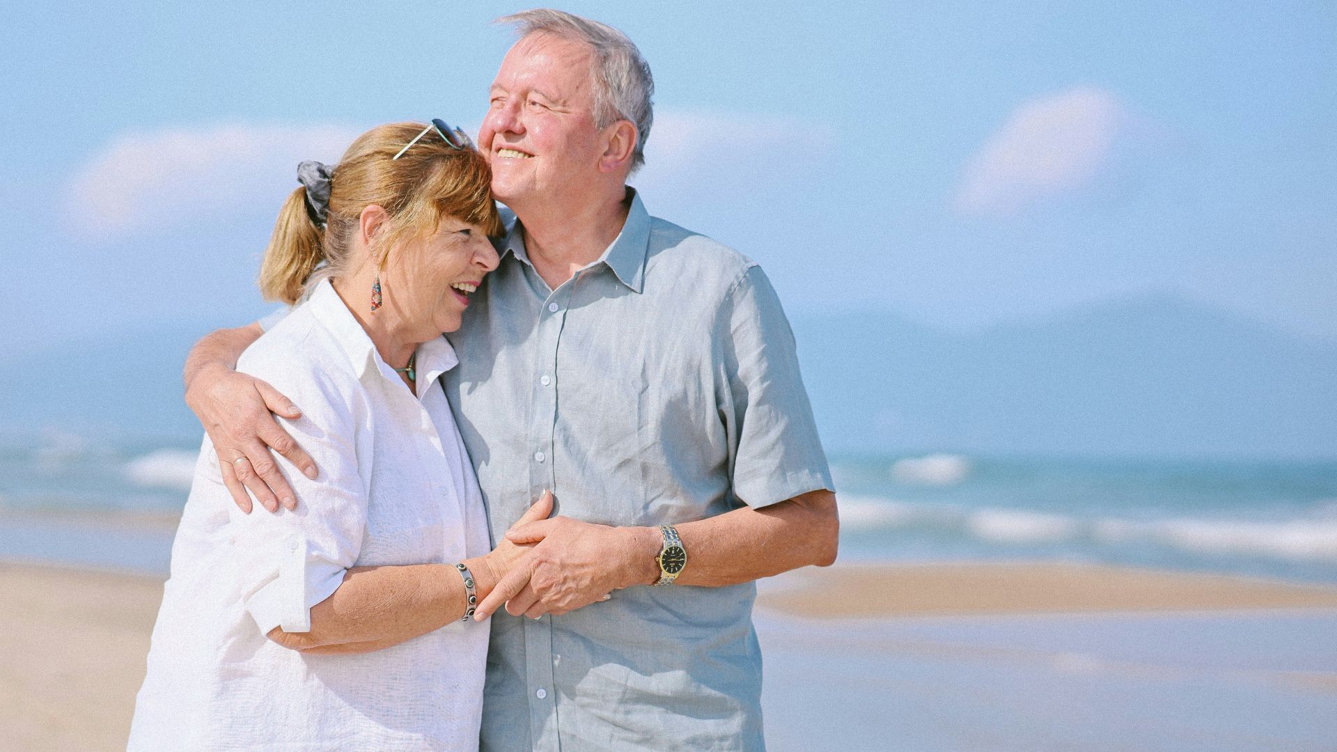 Elderly couple embracing on a sunny beach