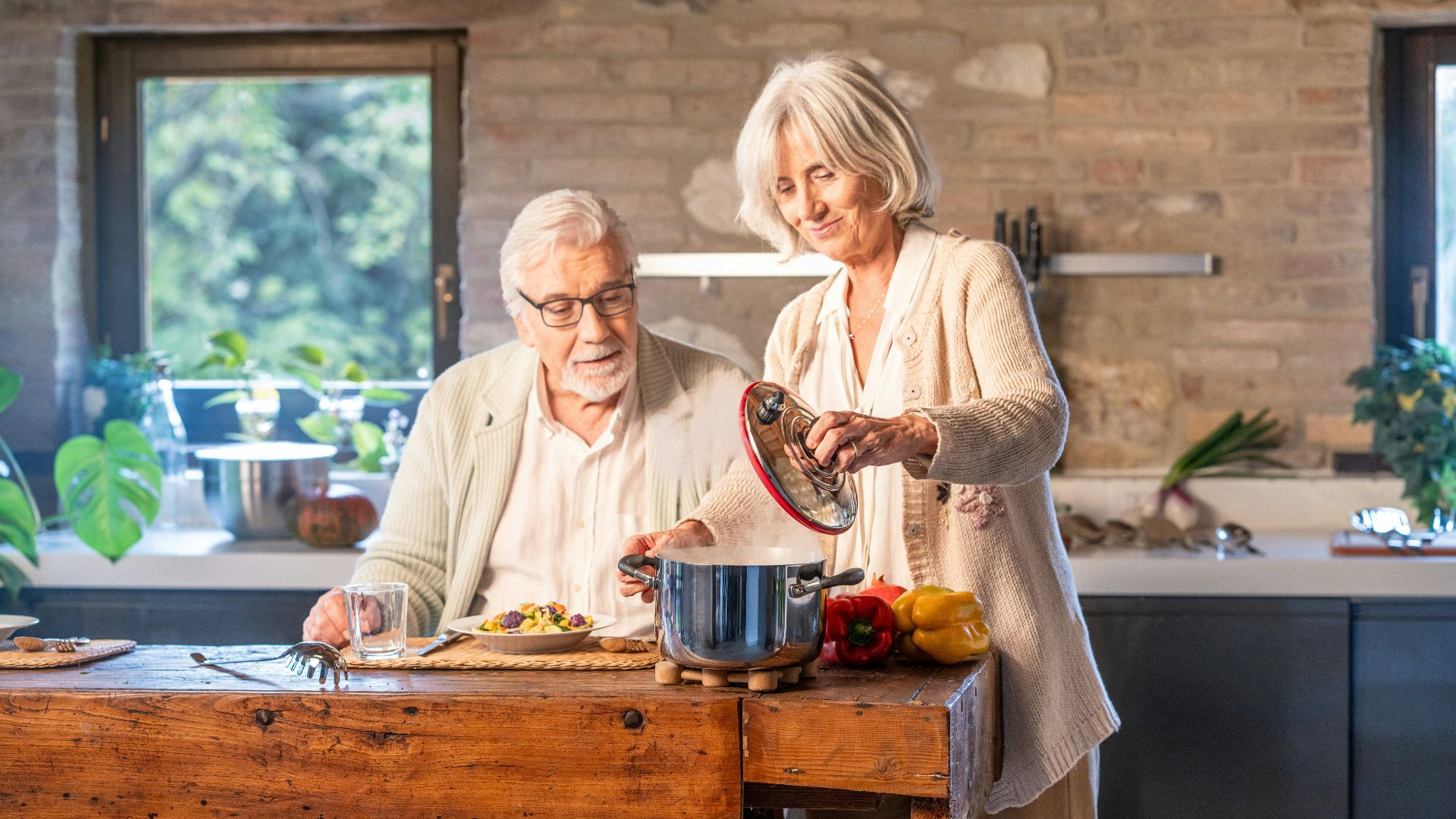Elderly couple cooking together in a modern kitchen.