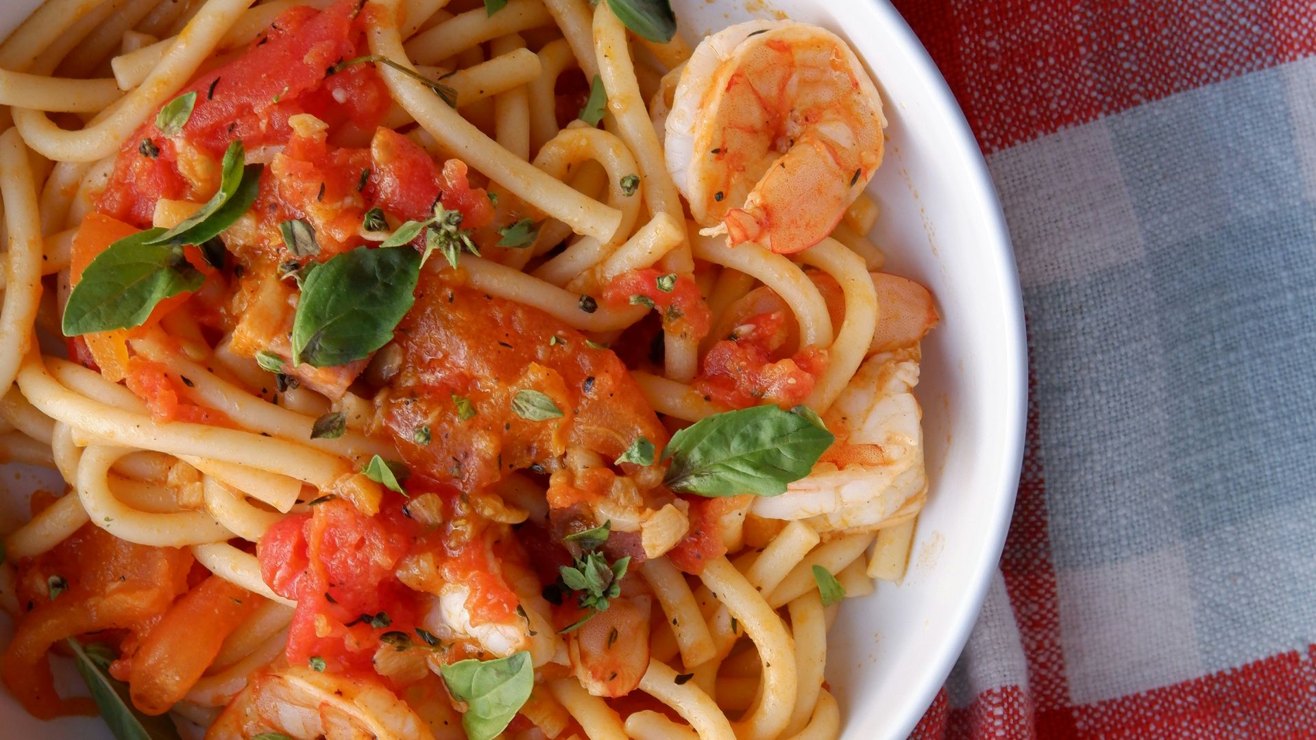a bowl of pasta with shrimp and tomato sauce