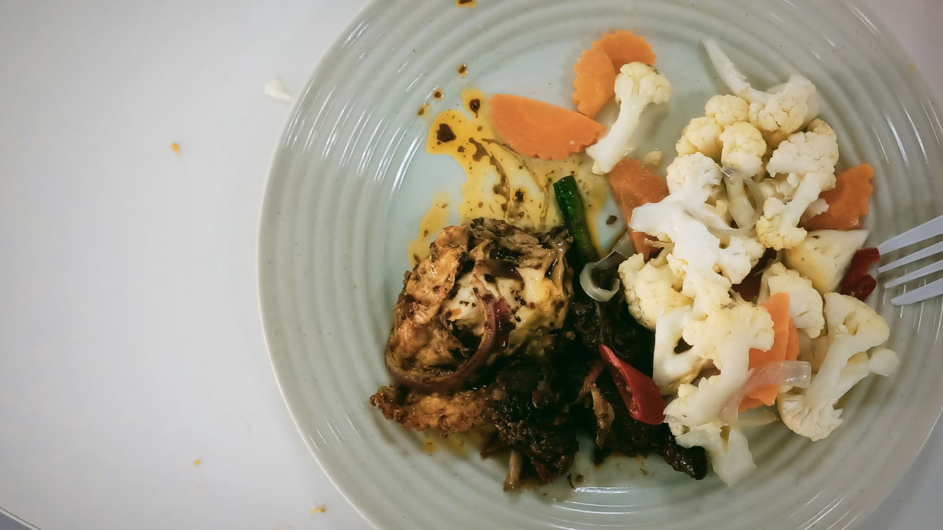 A white plate topped with meat and veggies