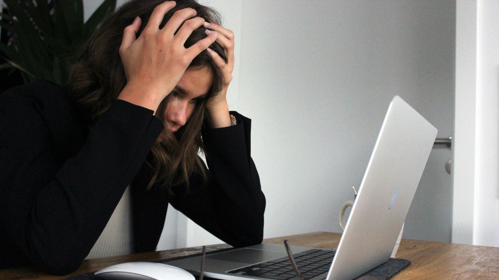 a woman sitting in front of a laptop computer