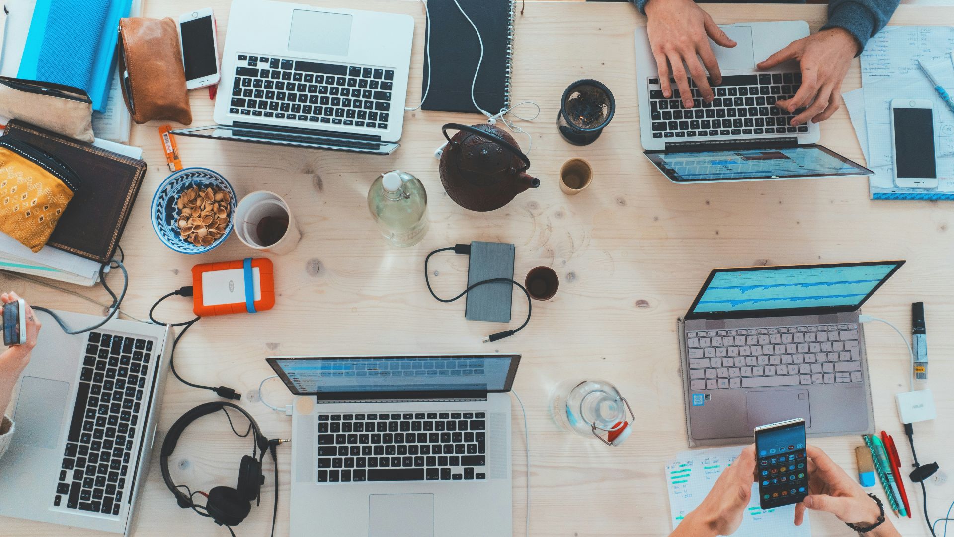 people sitting down near table with assorted laptop computers