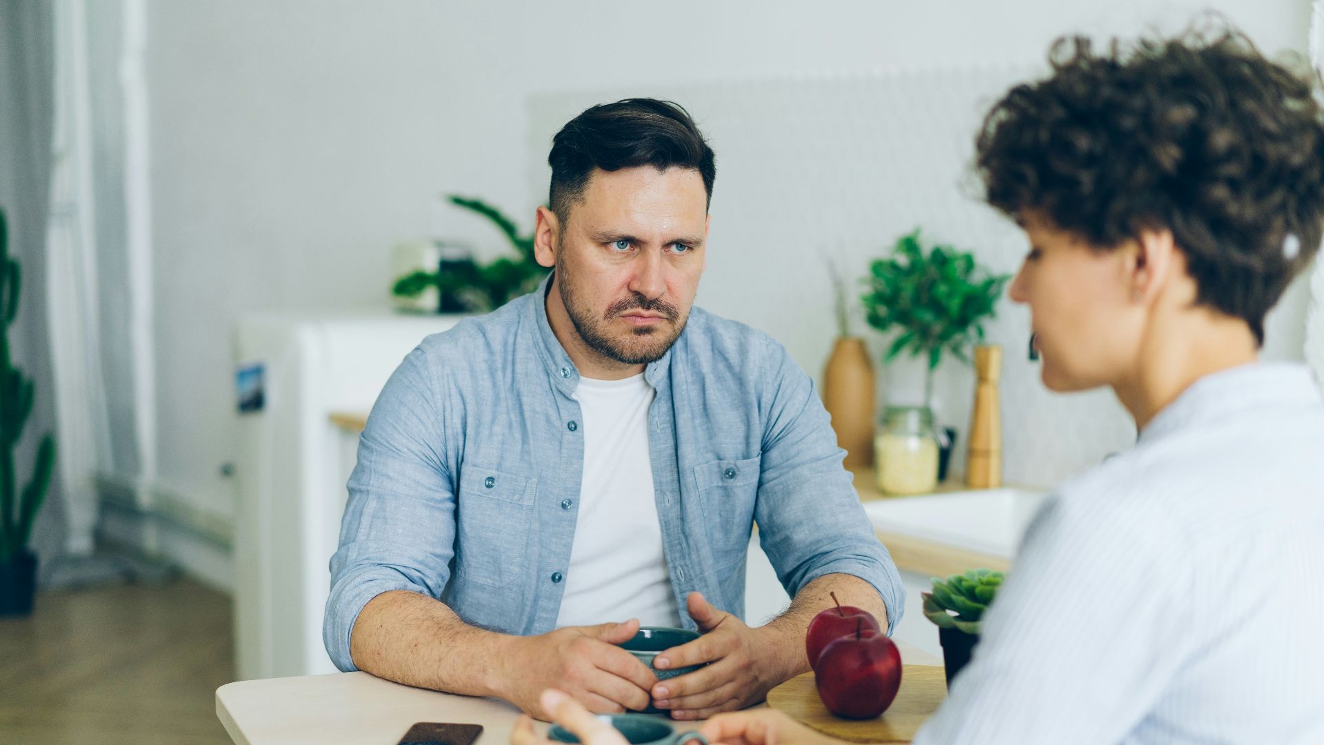 a man sitting at a table talking to a woman