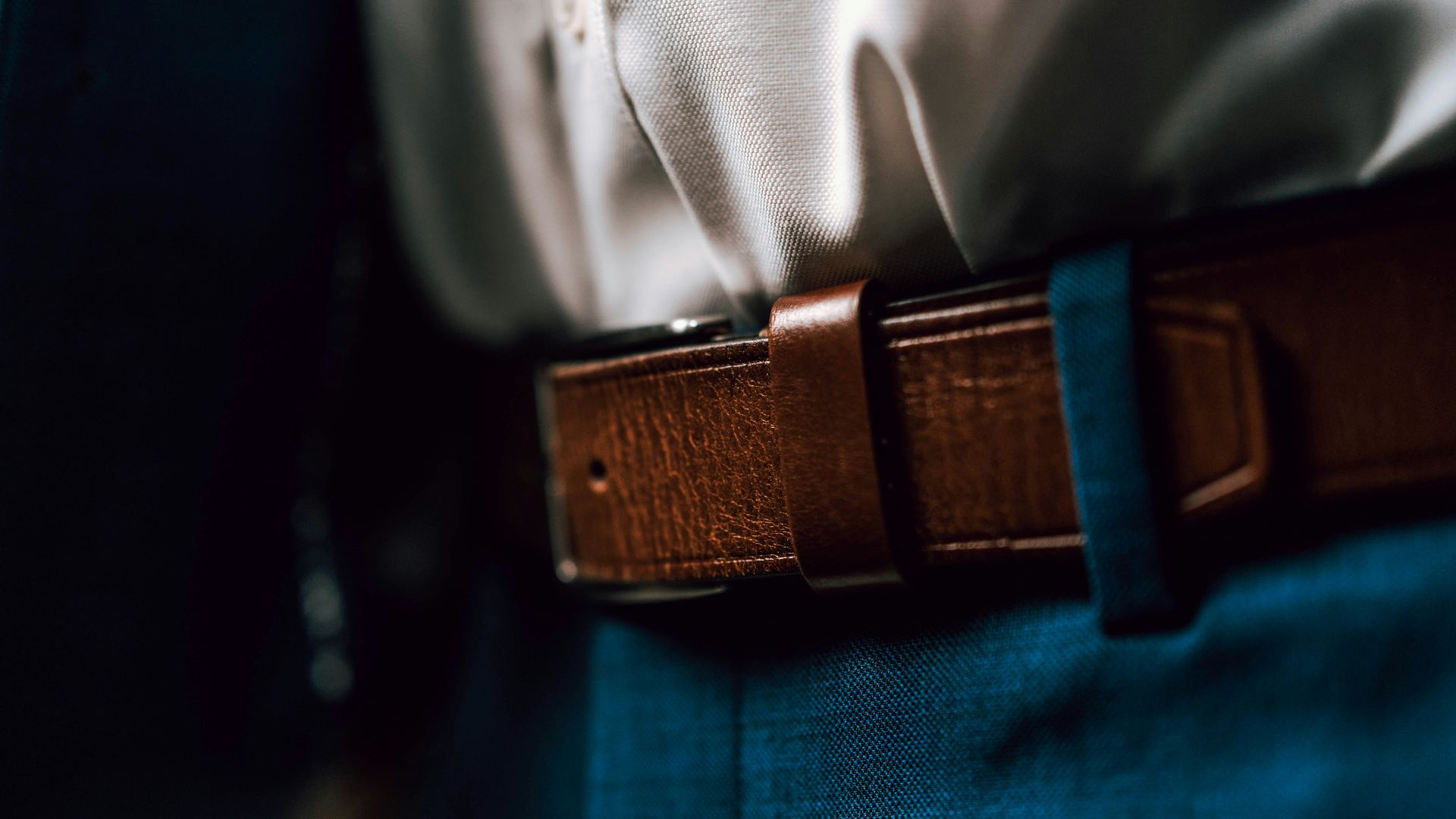 black leather belt on blue denim jeans