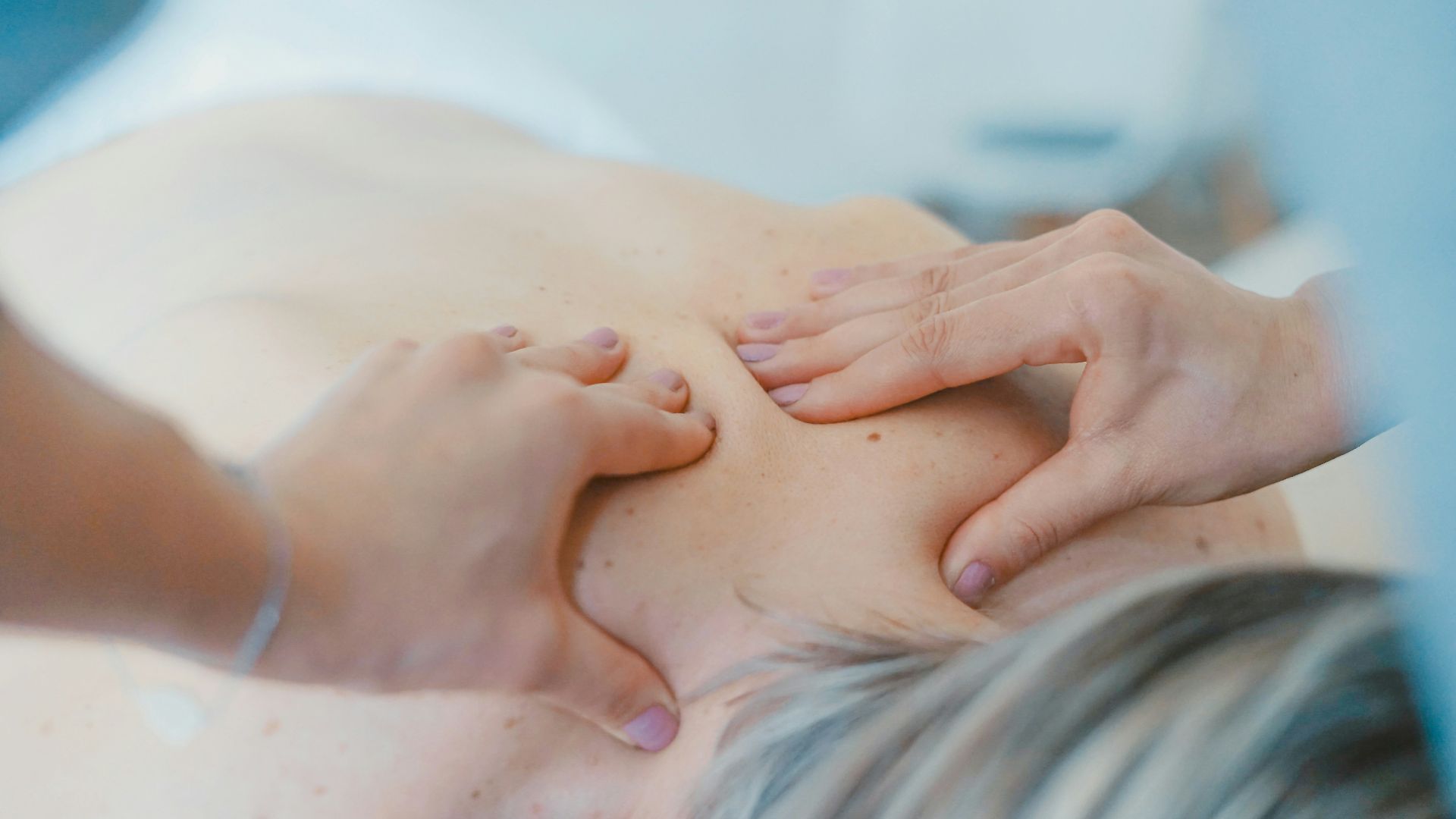 person massaging the back of a woman