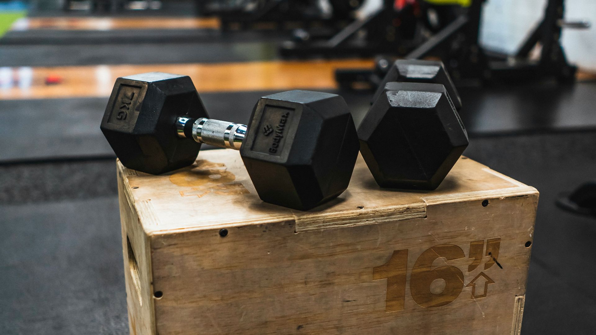 black and gray dumbbells on brown wooden crate
