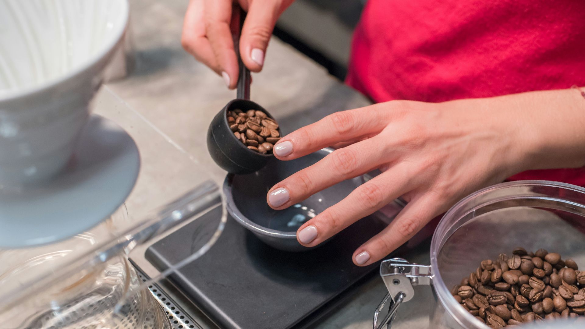 person scooping and measuring coffee beans