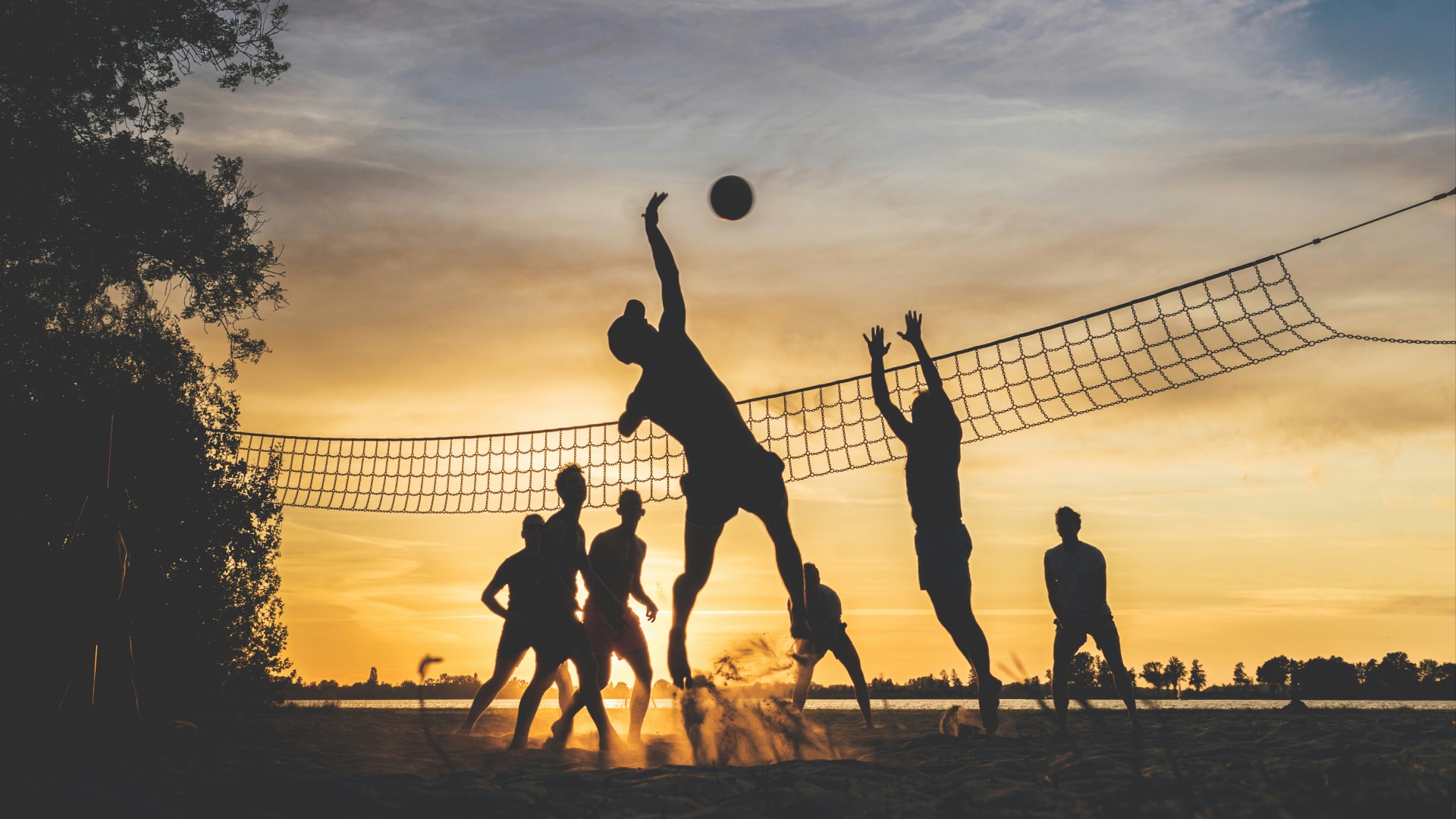 silhouette of people playing basketball during sunset