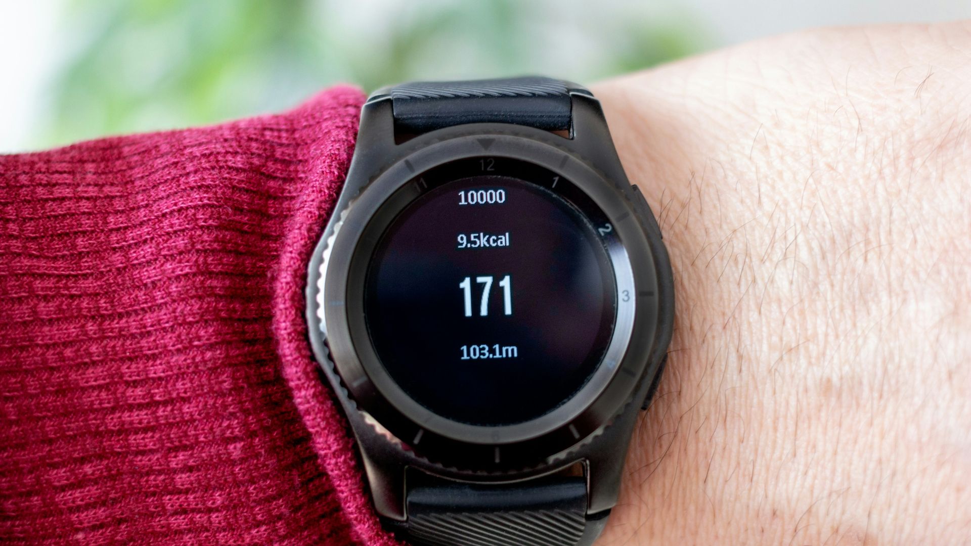 person wearing round black smartwatch