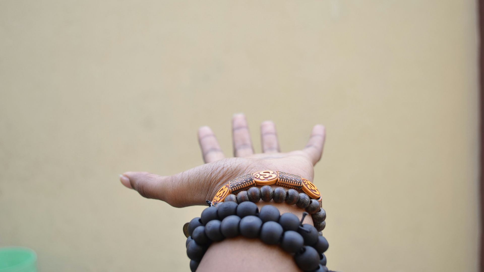 person hand with black beaded bracelets