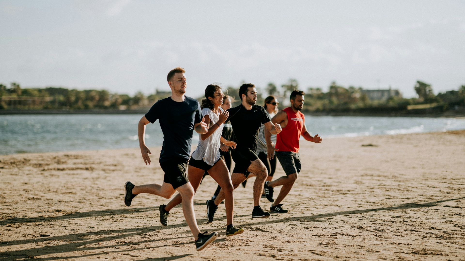 men and women running on sea shore