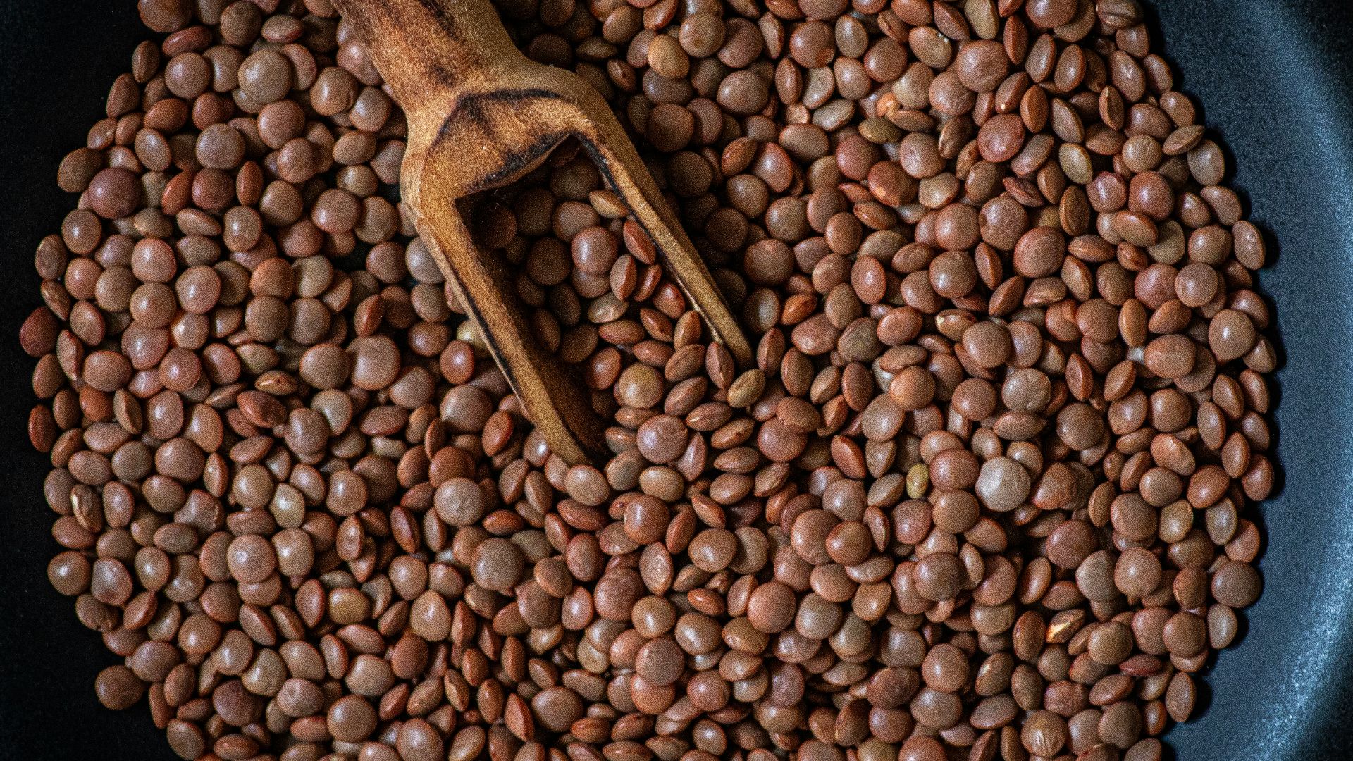 a pan filled with beans and a wooden spoon