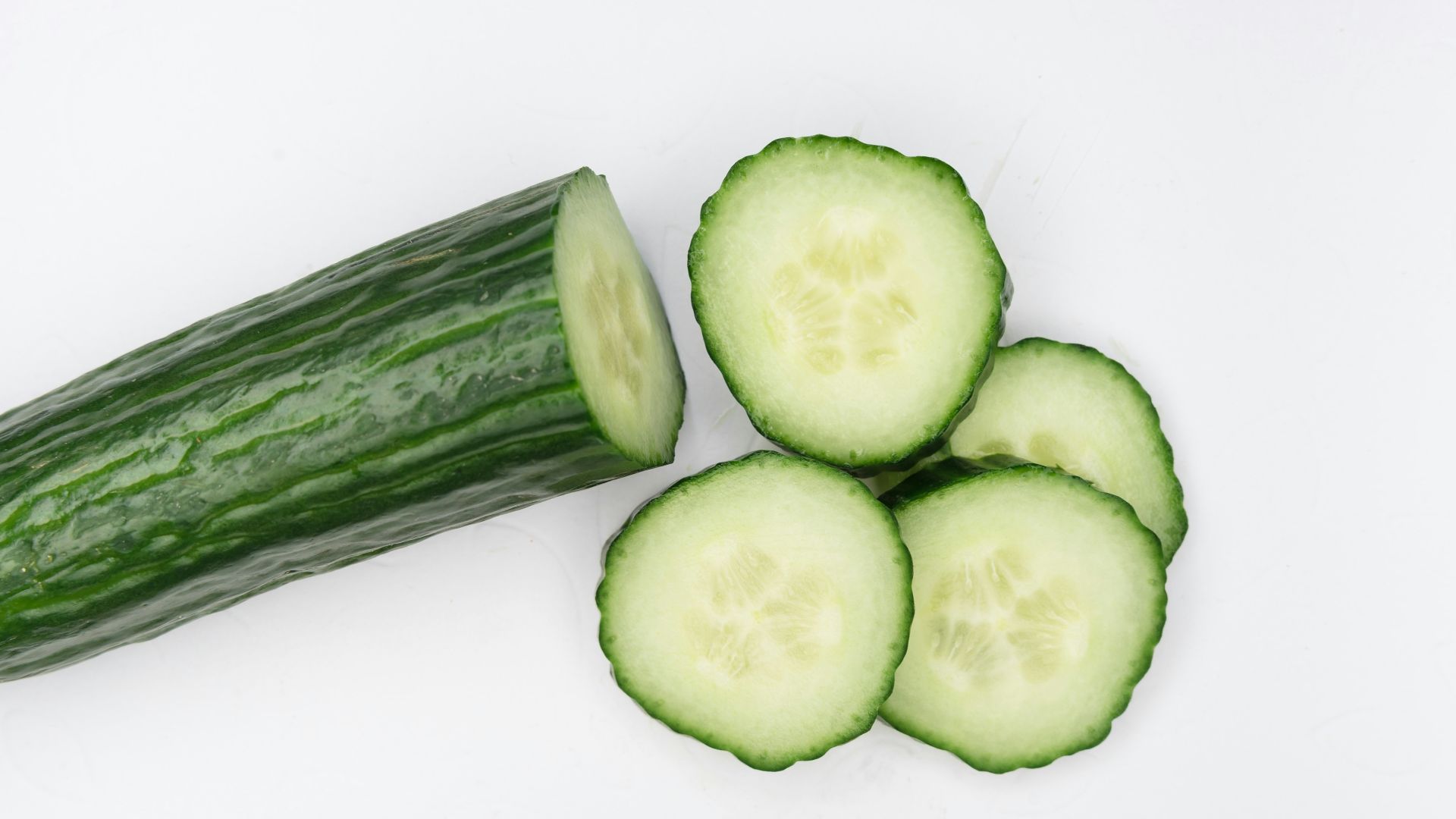 sliced cucumber on white surface