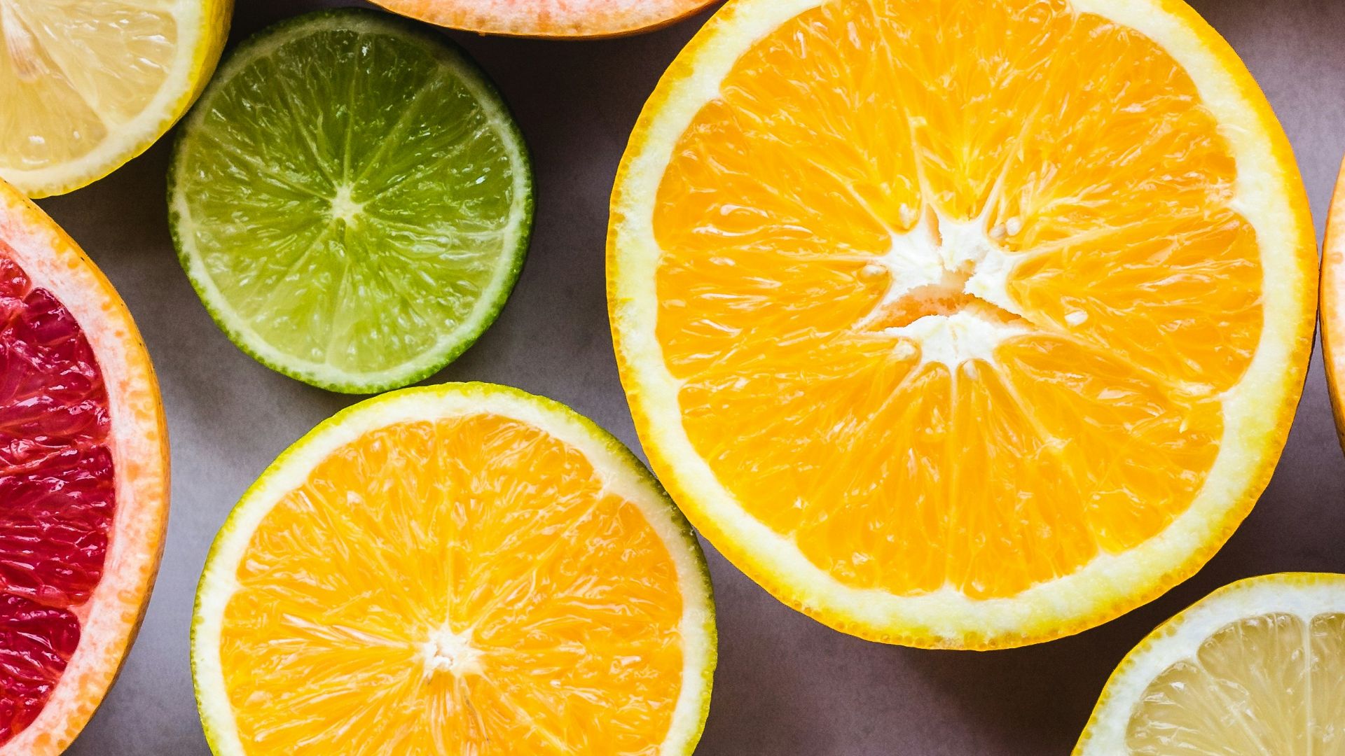 flat lay photography of sliced pomegranate, lime, and lemon